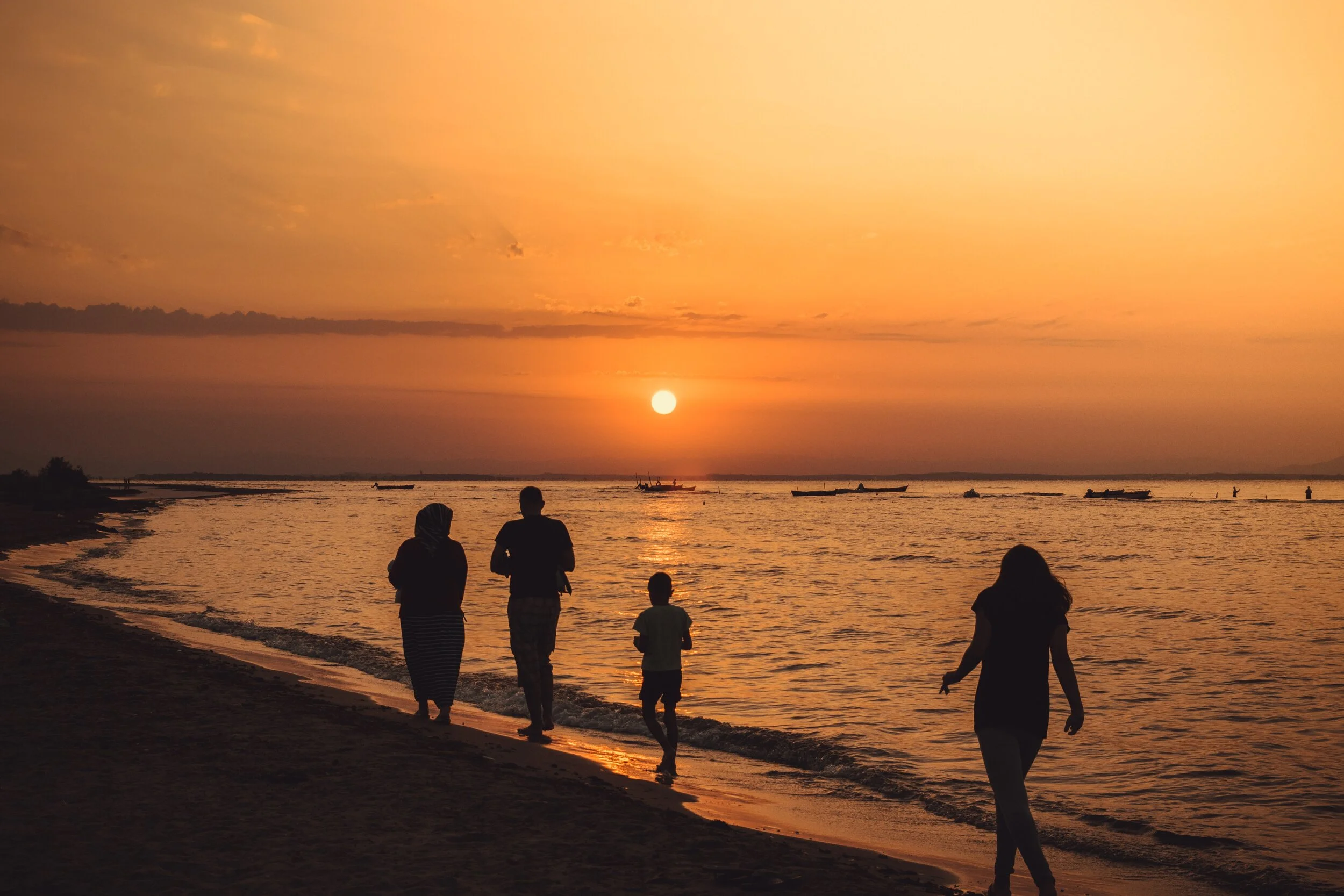 silhouette-of-people-walking-on-seashore-during-sunset-1129615.jpg