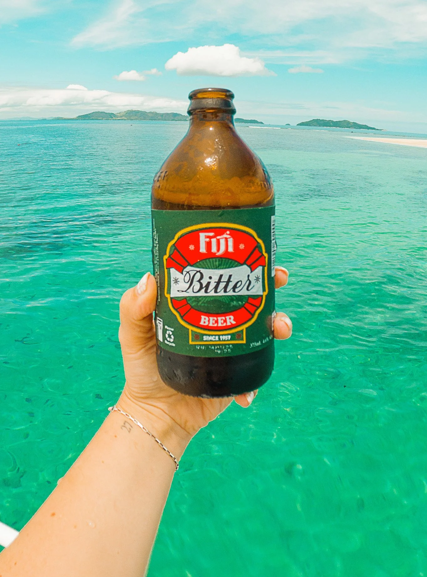 fiji bitter beer in front of ocean