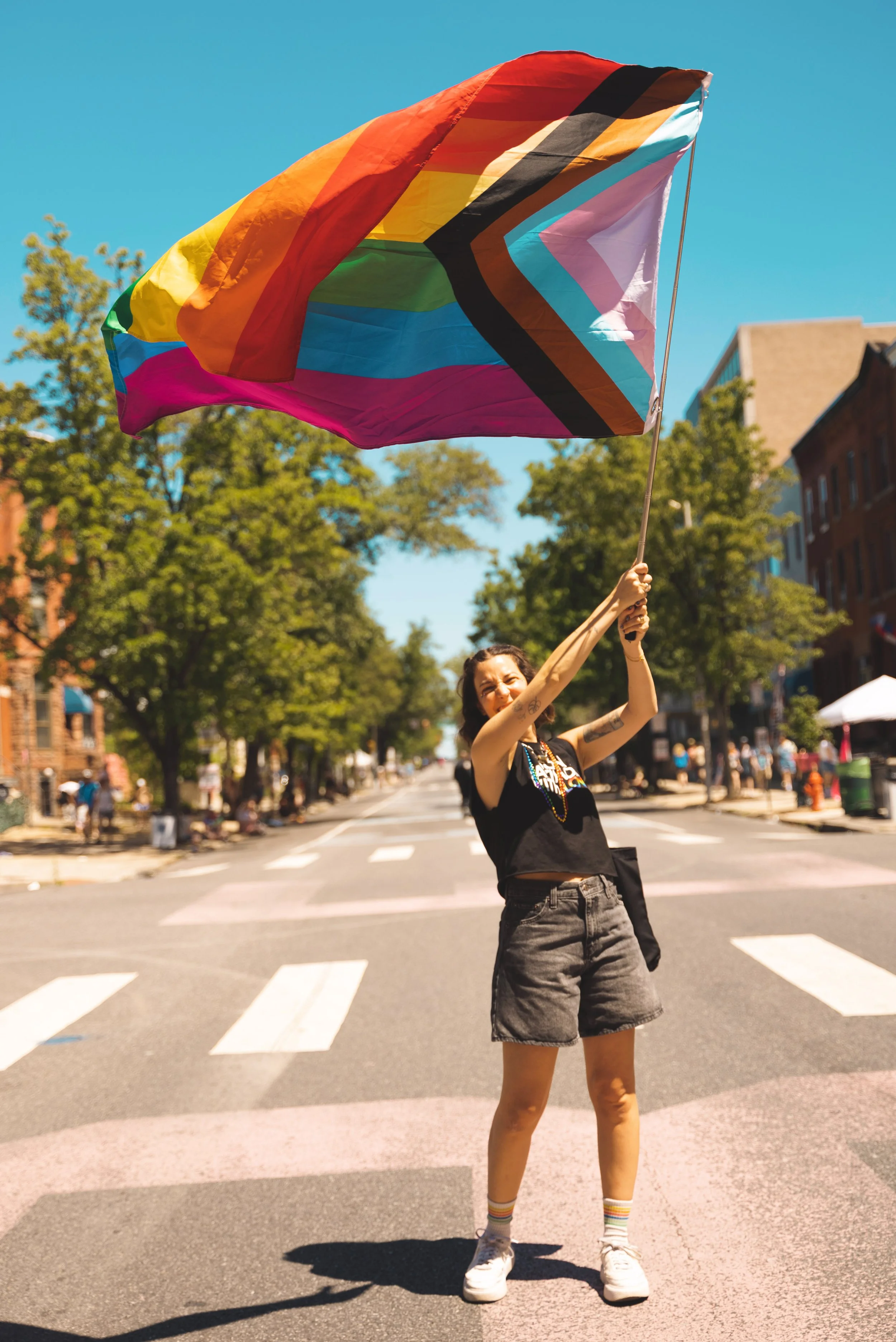 girl waving rainbow flag at baltimore pride