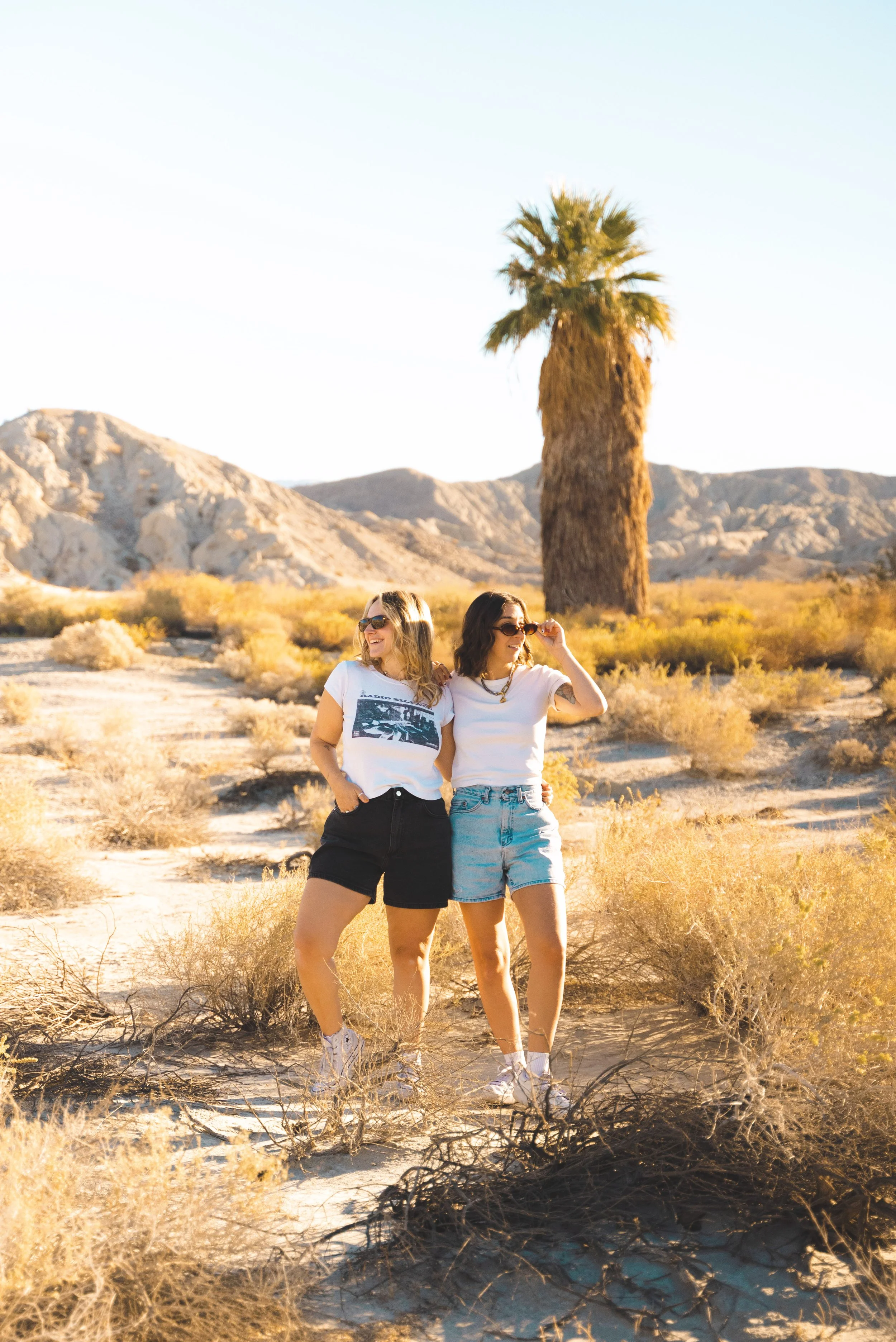 two girls standing in desert of coachella valley on red jeep tour palm springs