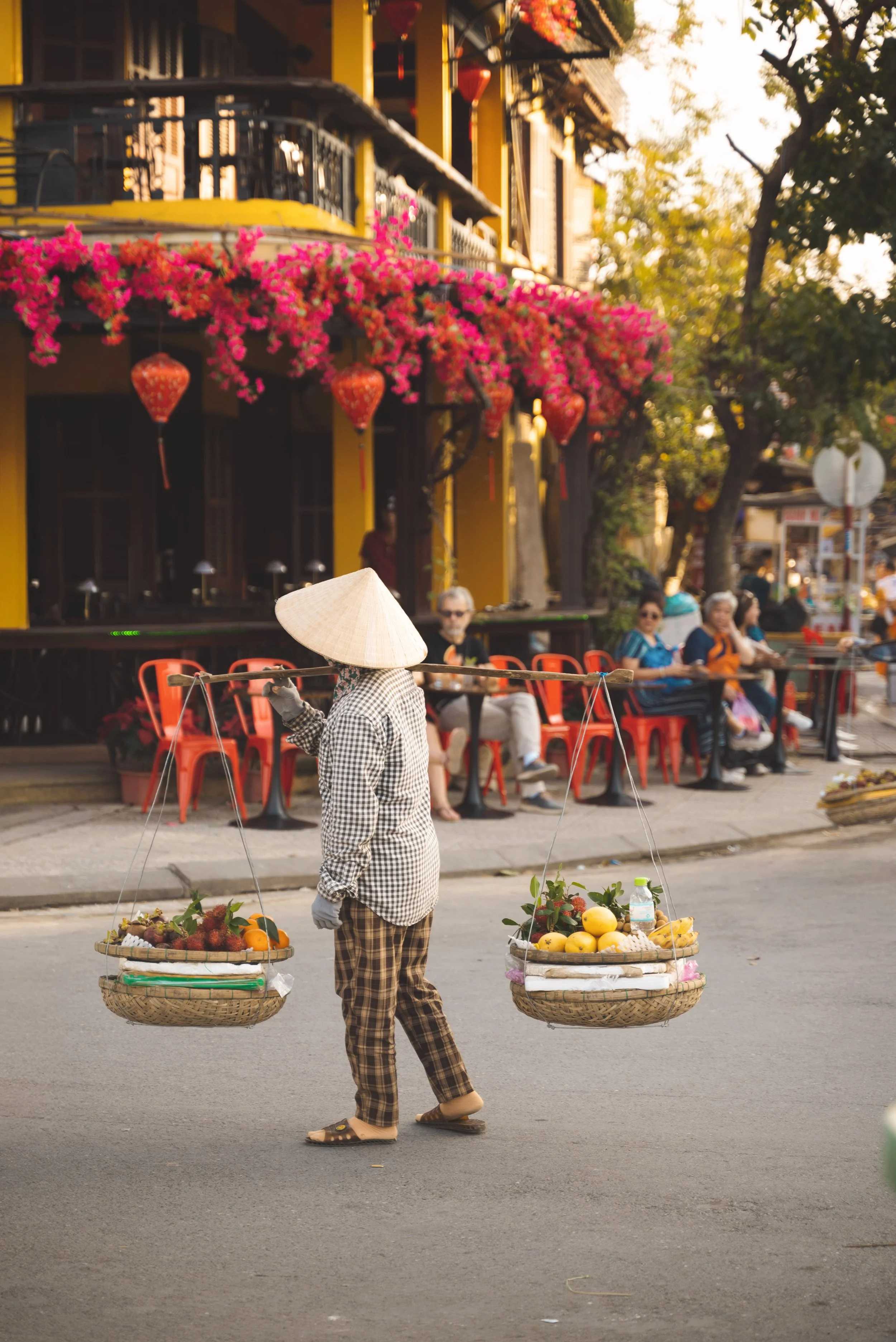 vietnamese woman holding baskets of fruit