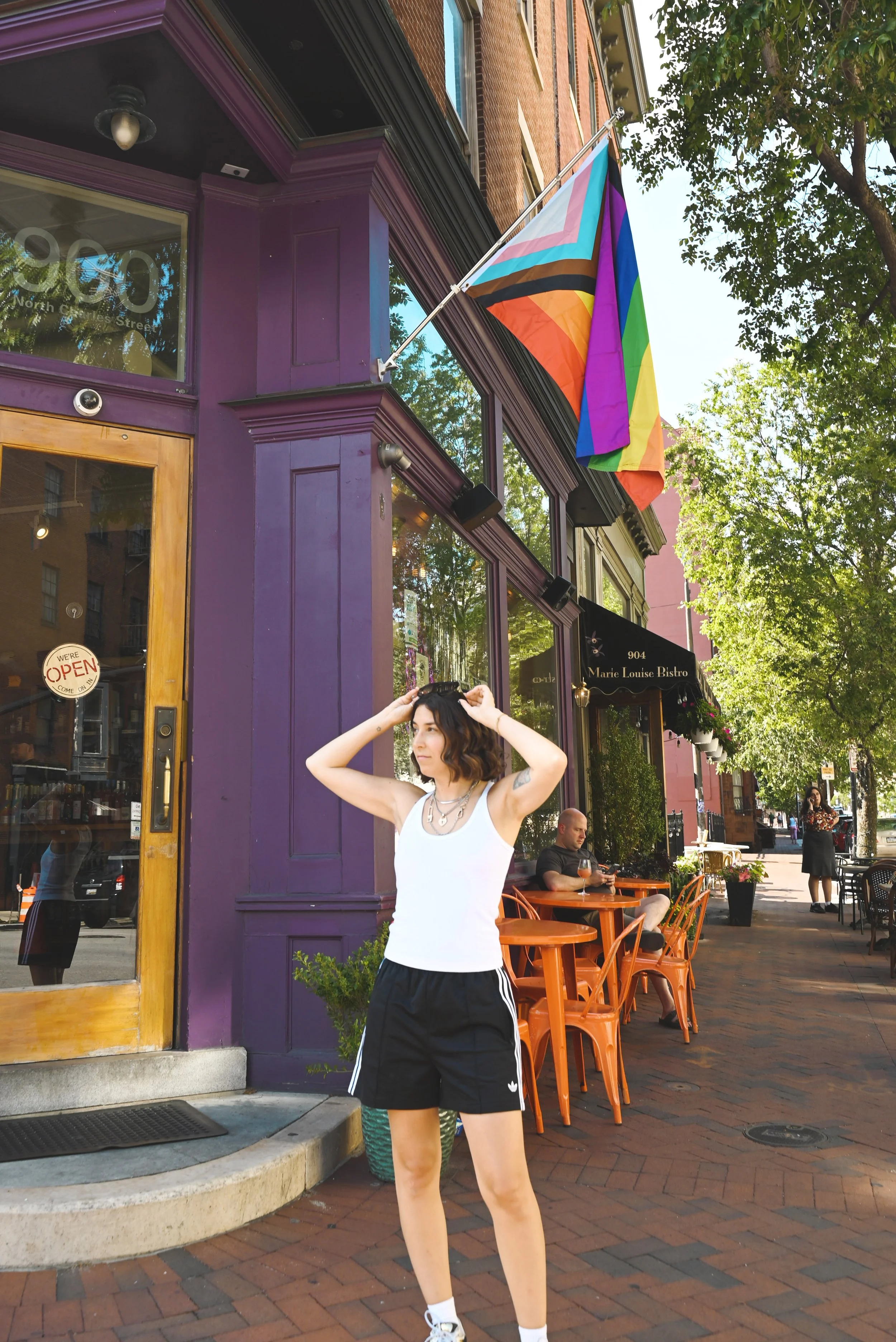 girl standing in front of pride flag in baltimore
