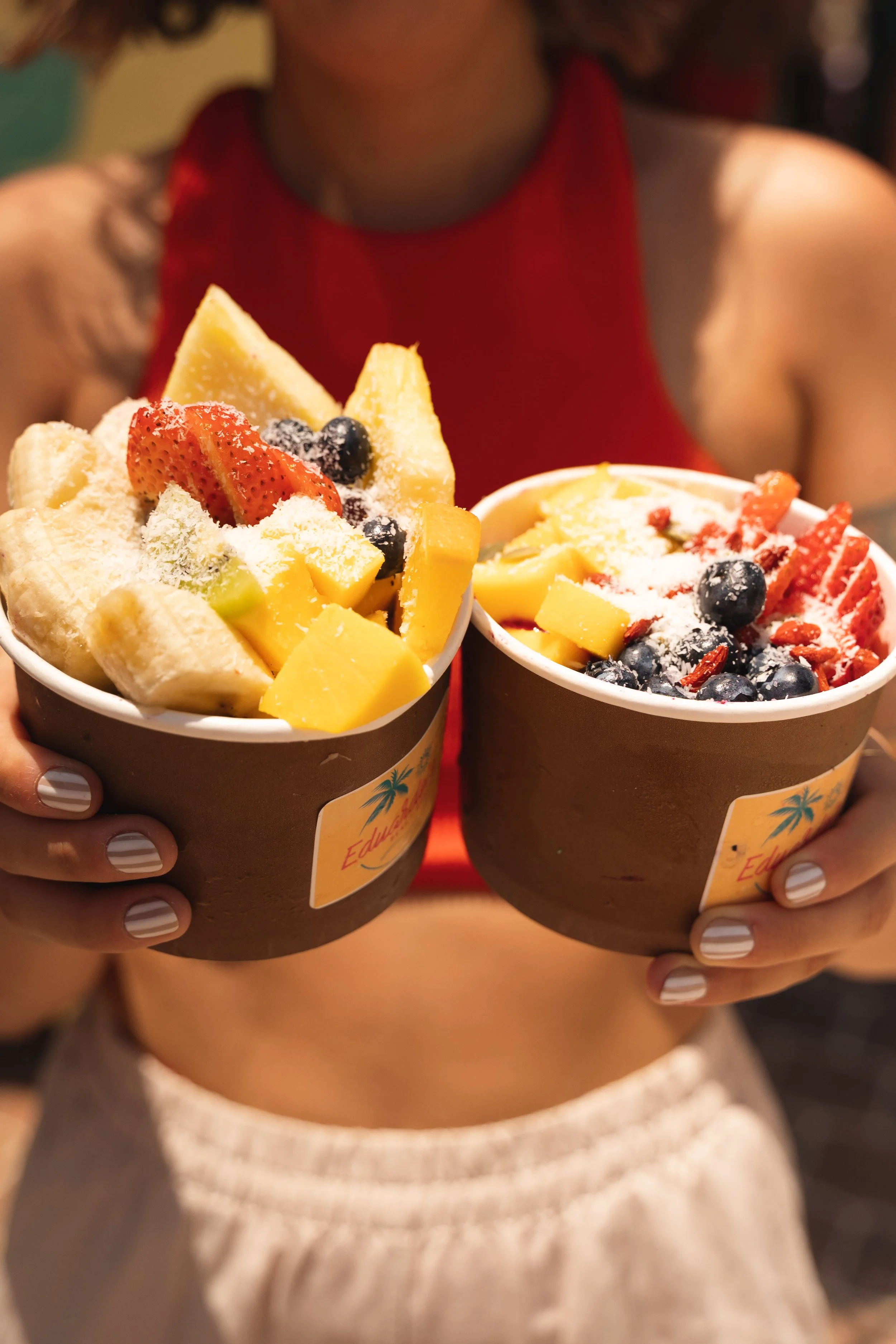 girl holding eduardo's beach shack acai bowls aruba