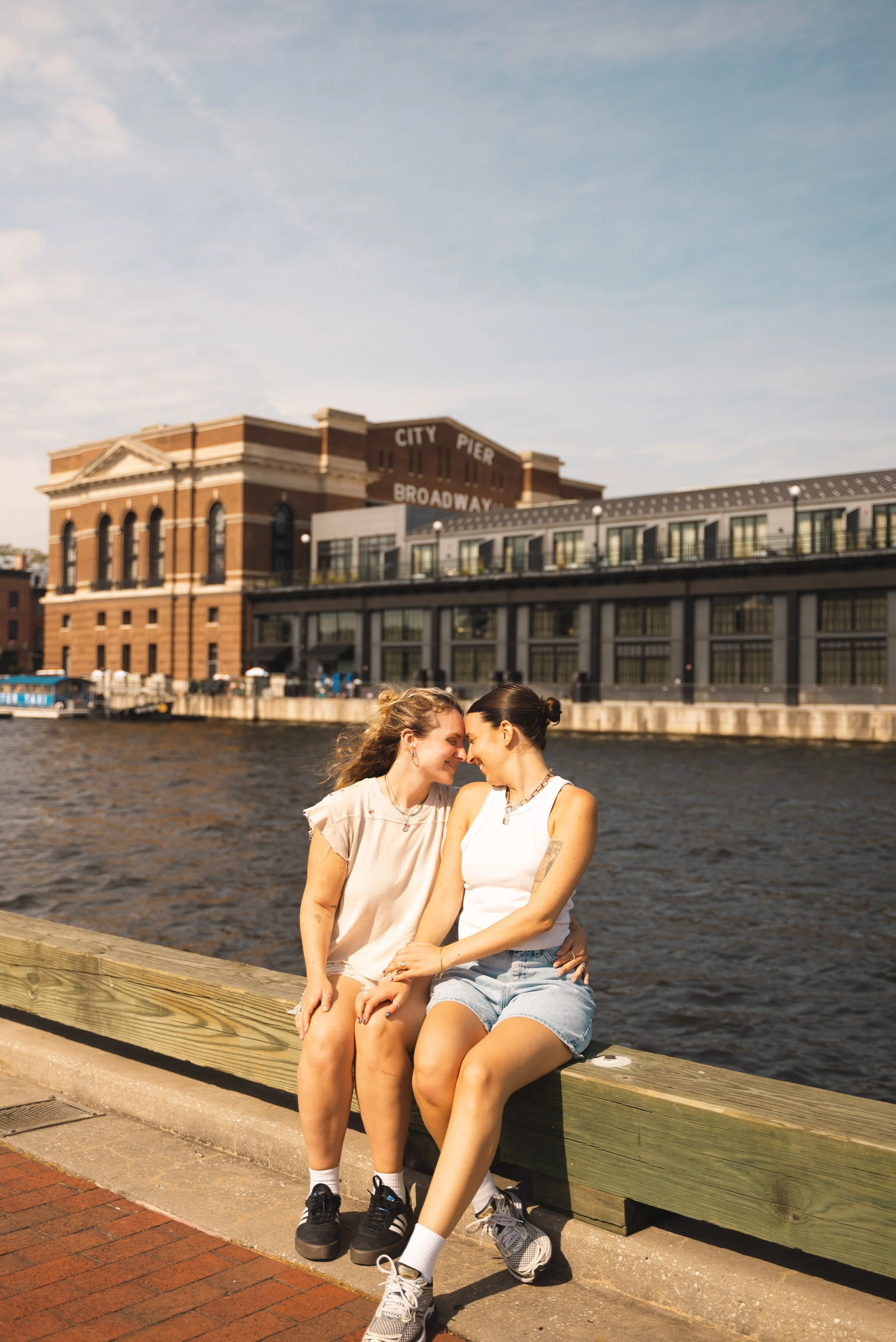 two girl sitting in pier at fell's point baltimore