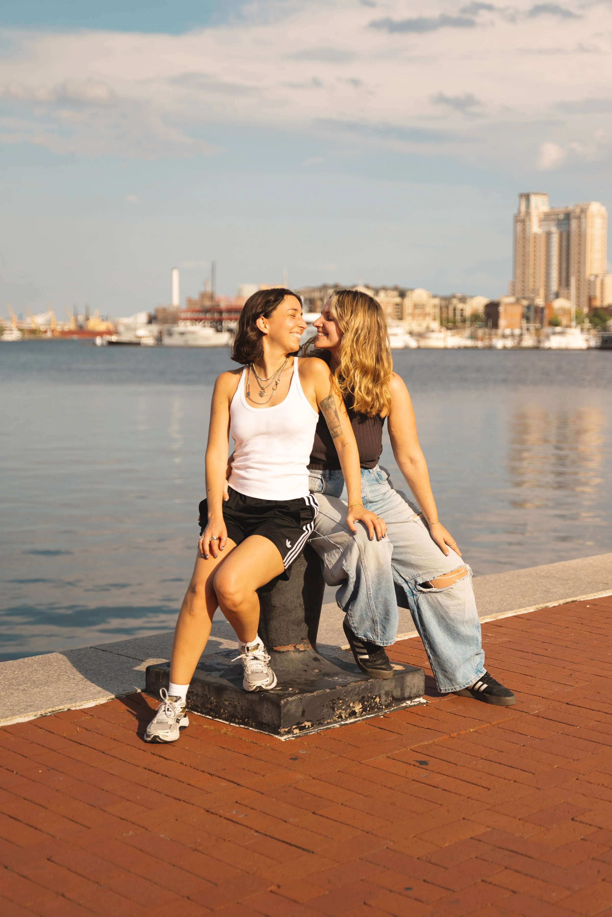 two girls sitting in front of baltimore inner harbor
