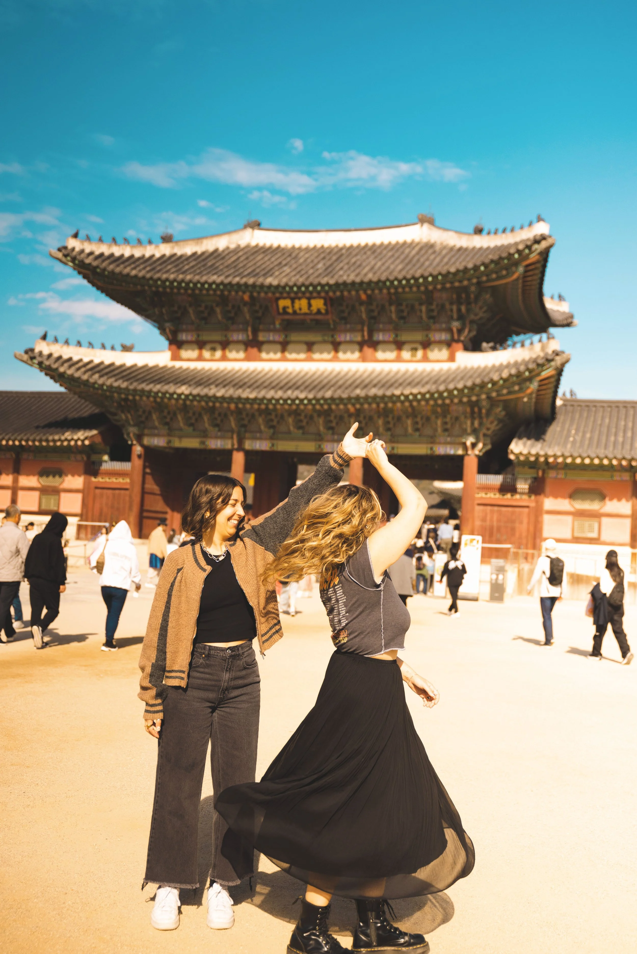 two girls dancing in front of Gyeongbokgung Palace seoul