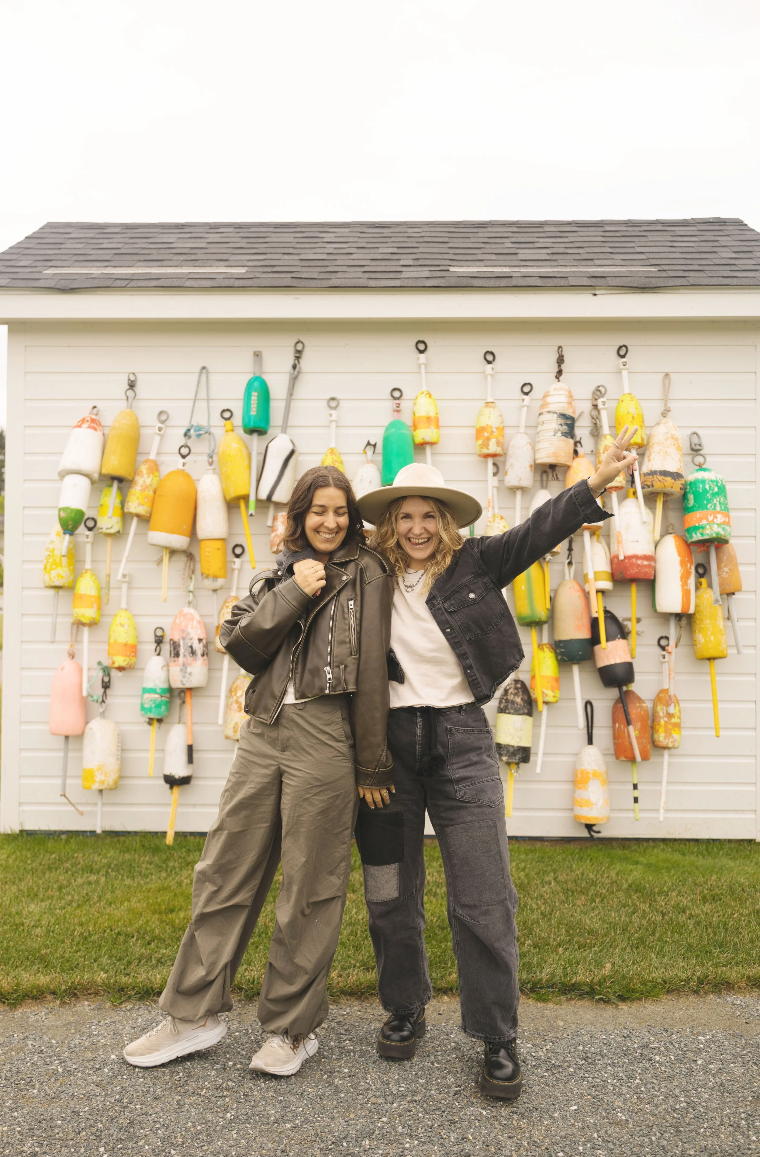 two girls in front of colorful buoys in maine