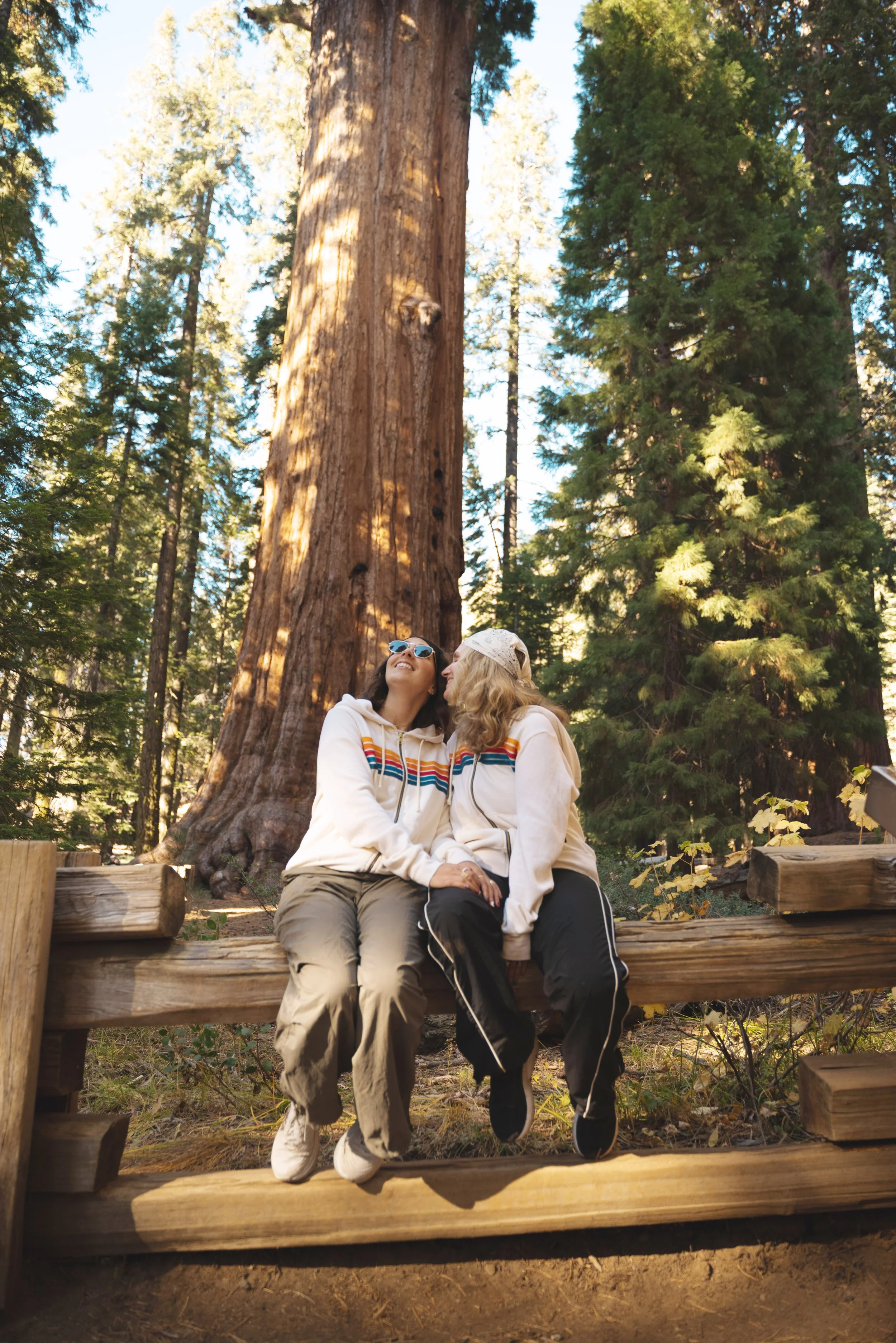 two girls sitting in front of general sherman tree in sequoia national park