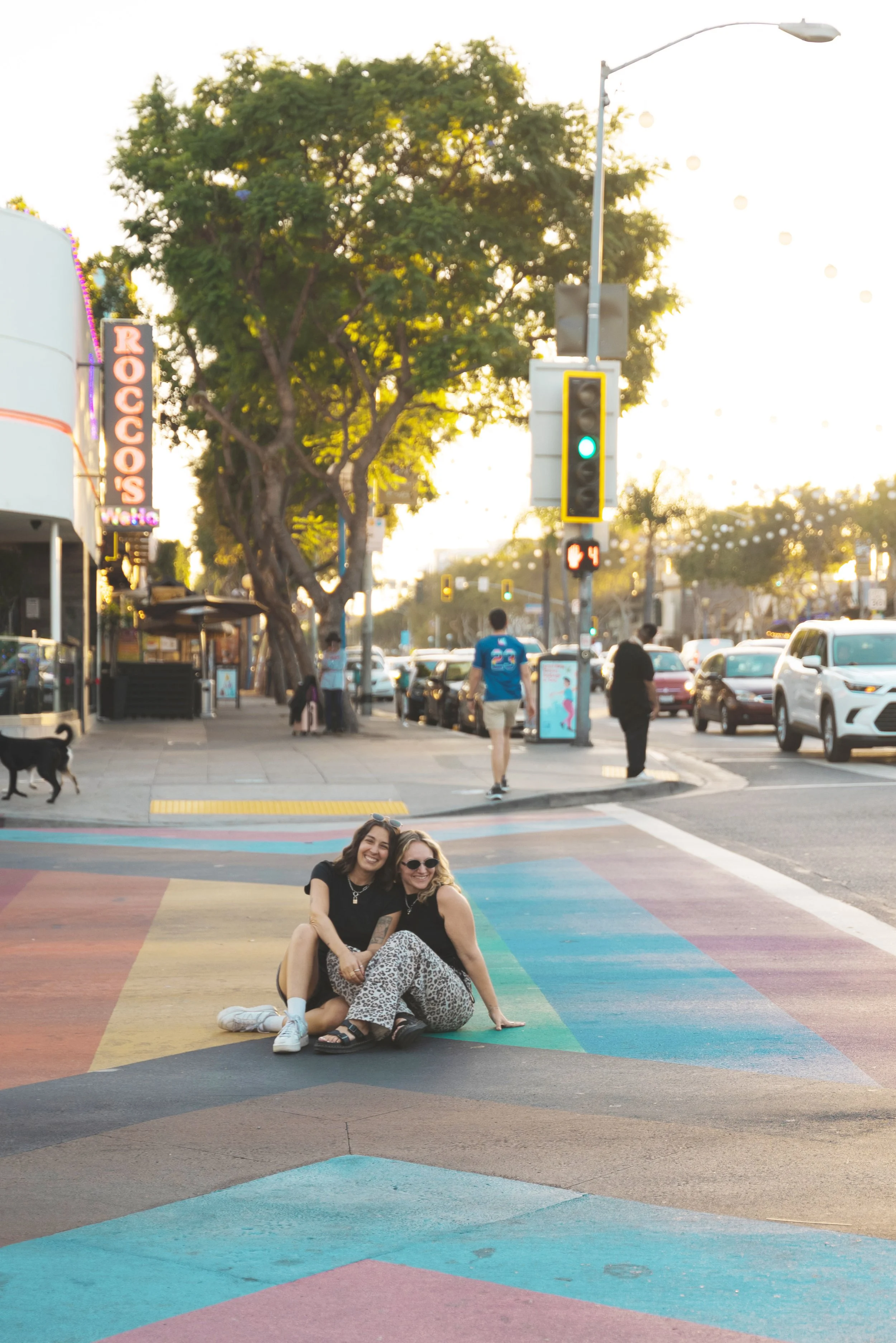 two girls sitting in rainbow crosswalk in west hollywood