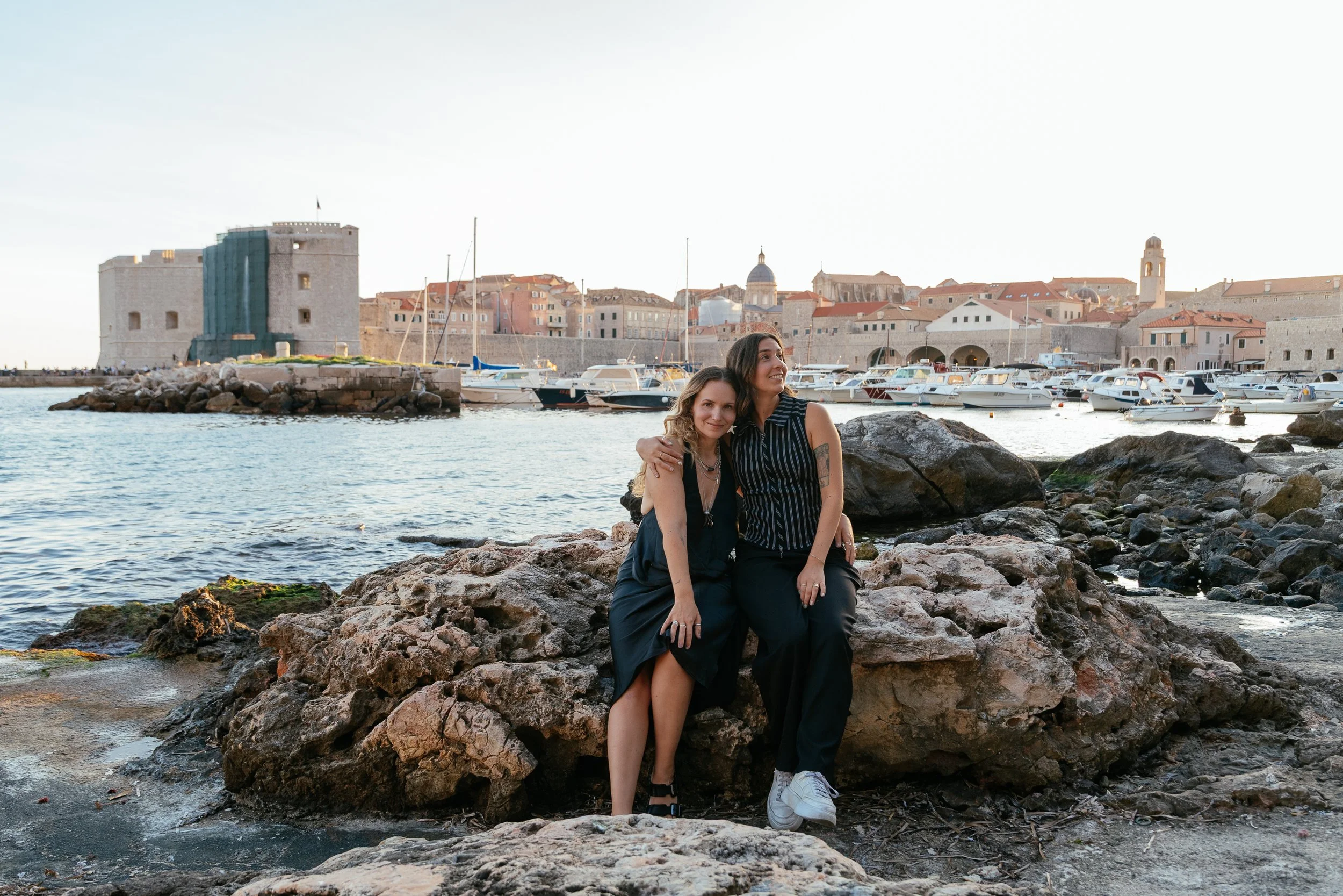 two girls sitting on dubrovnik waterfront