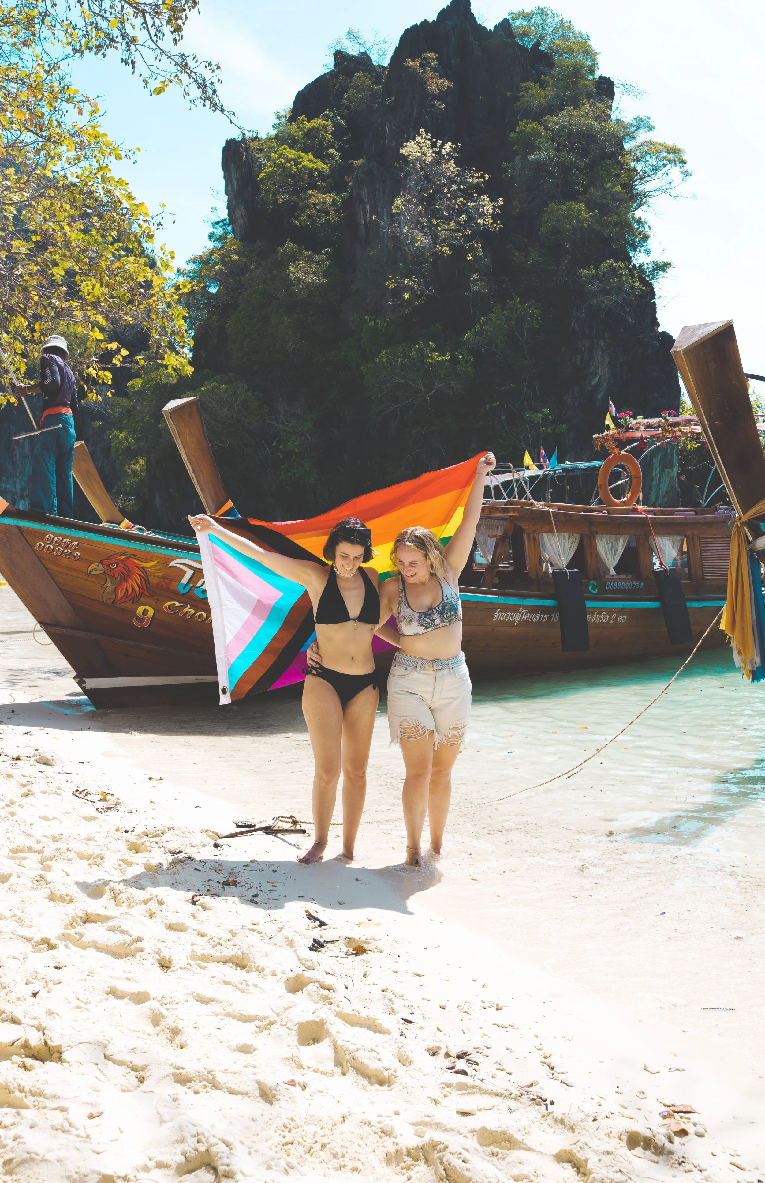 two girls holding pride flag in krabi thailand