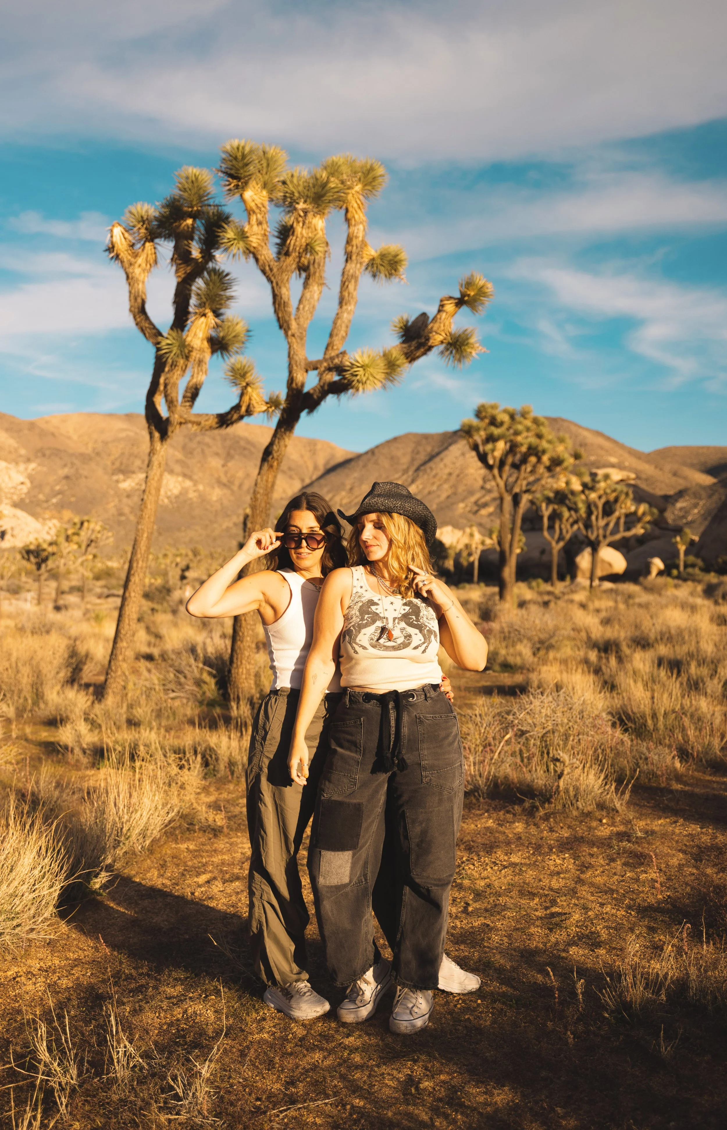 two girls standing in front of a joshua tree in Joshua Tree National Park
