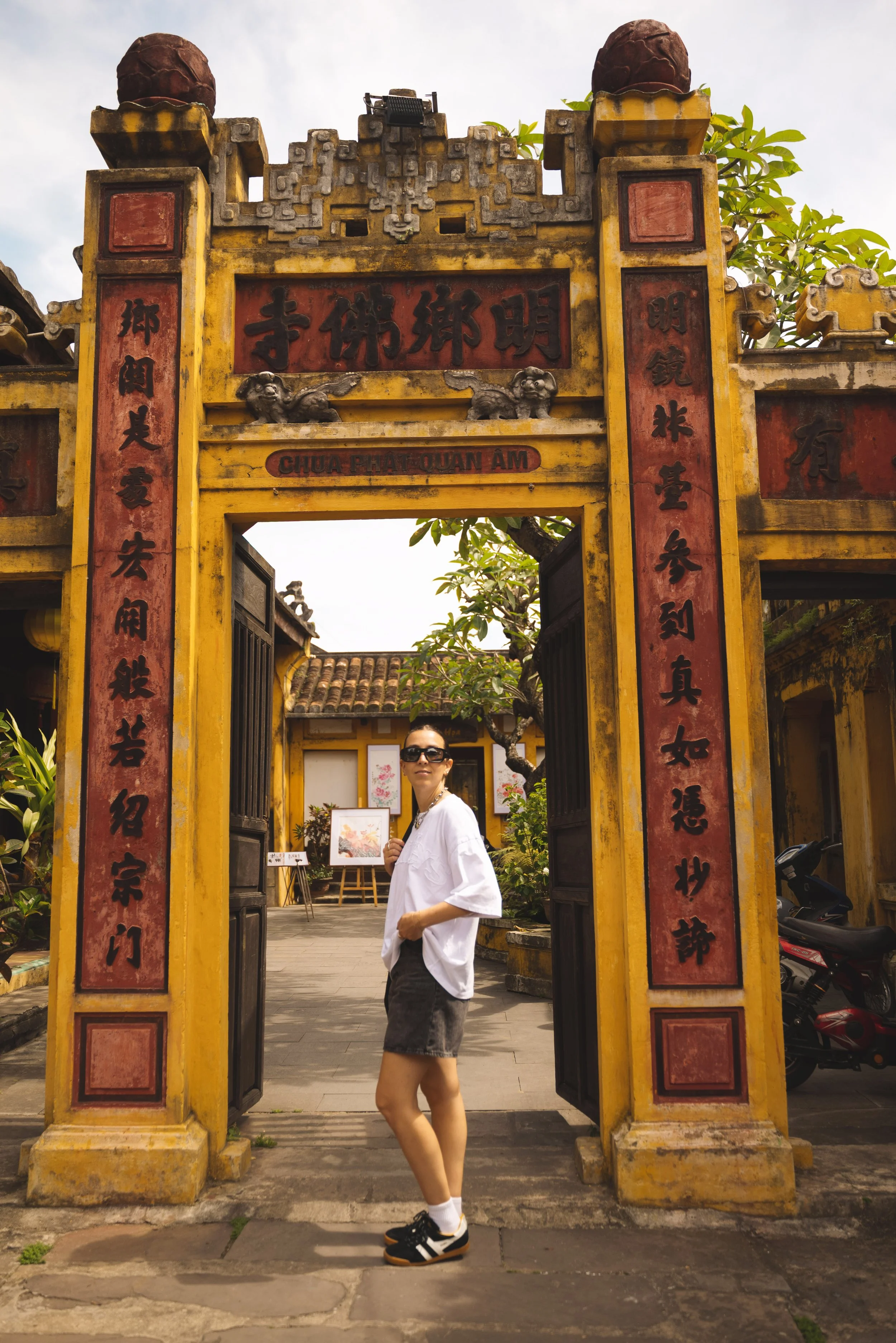girl standing in front of temple gates hoi an vietnam