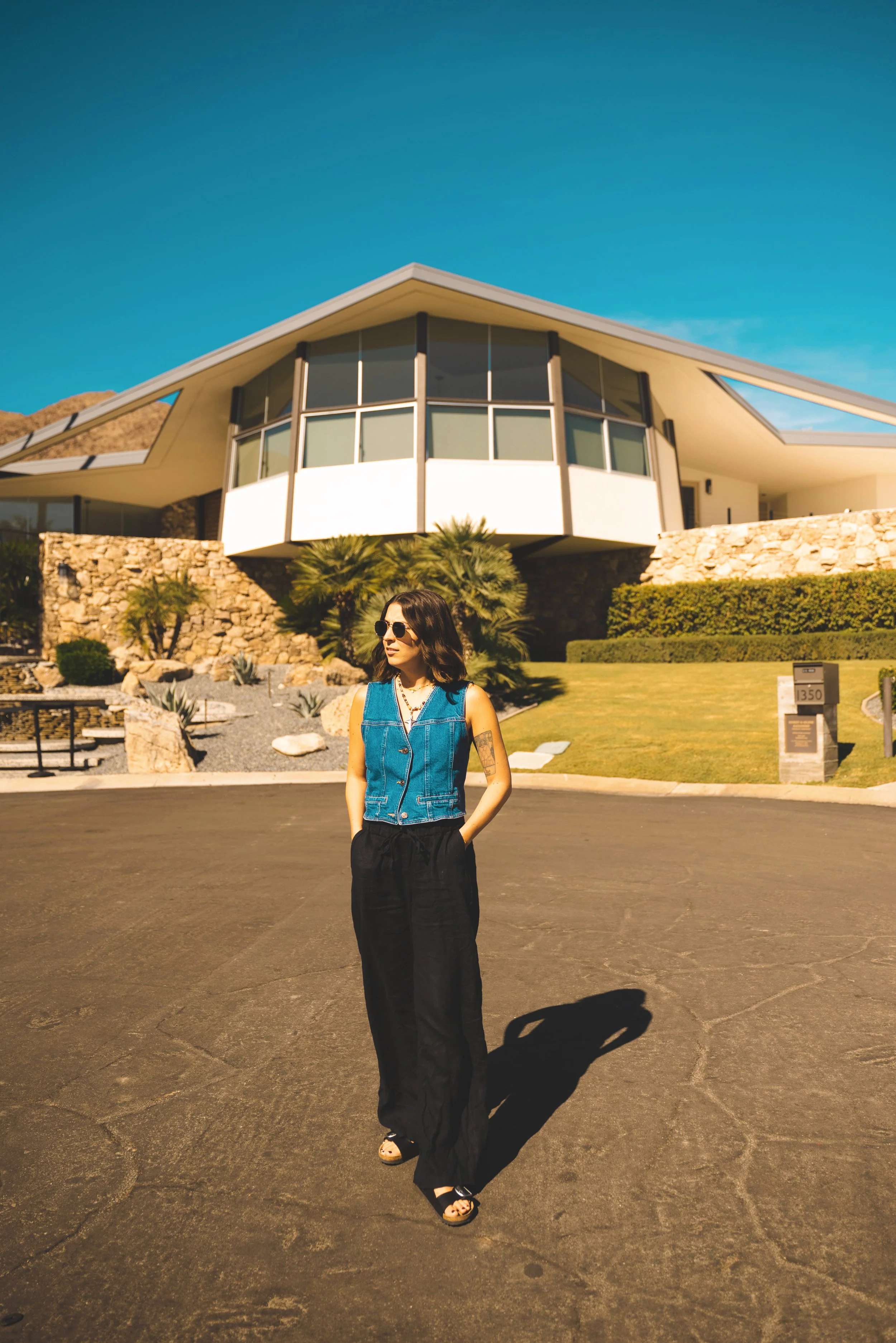 girl standing in front of midcentury modern house in palm springs