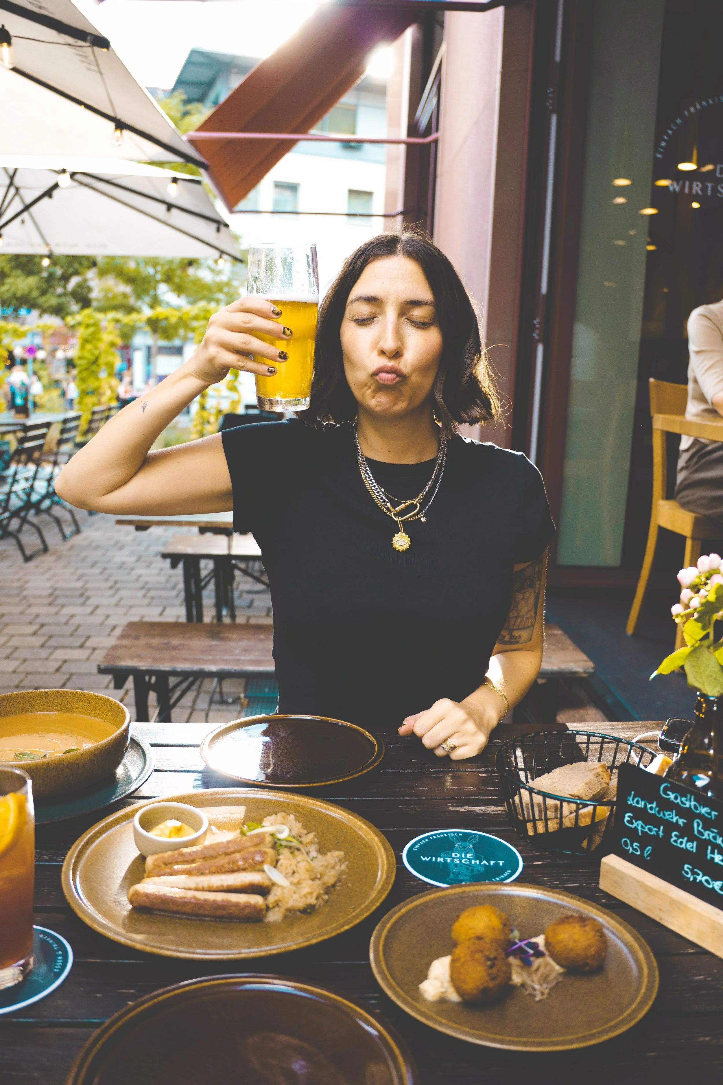 girl holding up german beer at dinner in Nuremberg