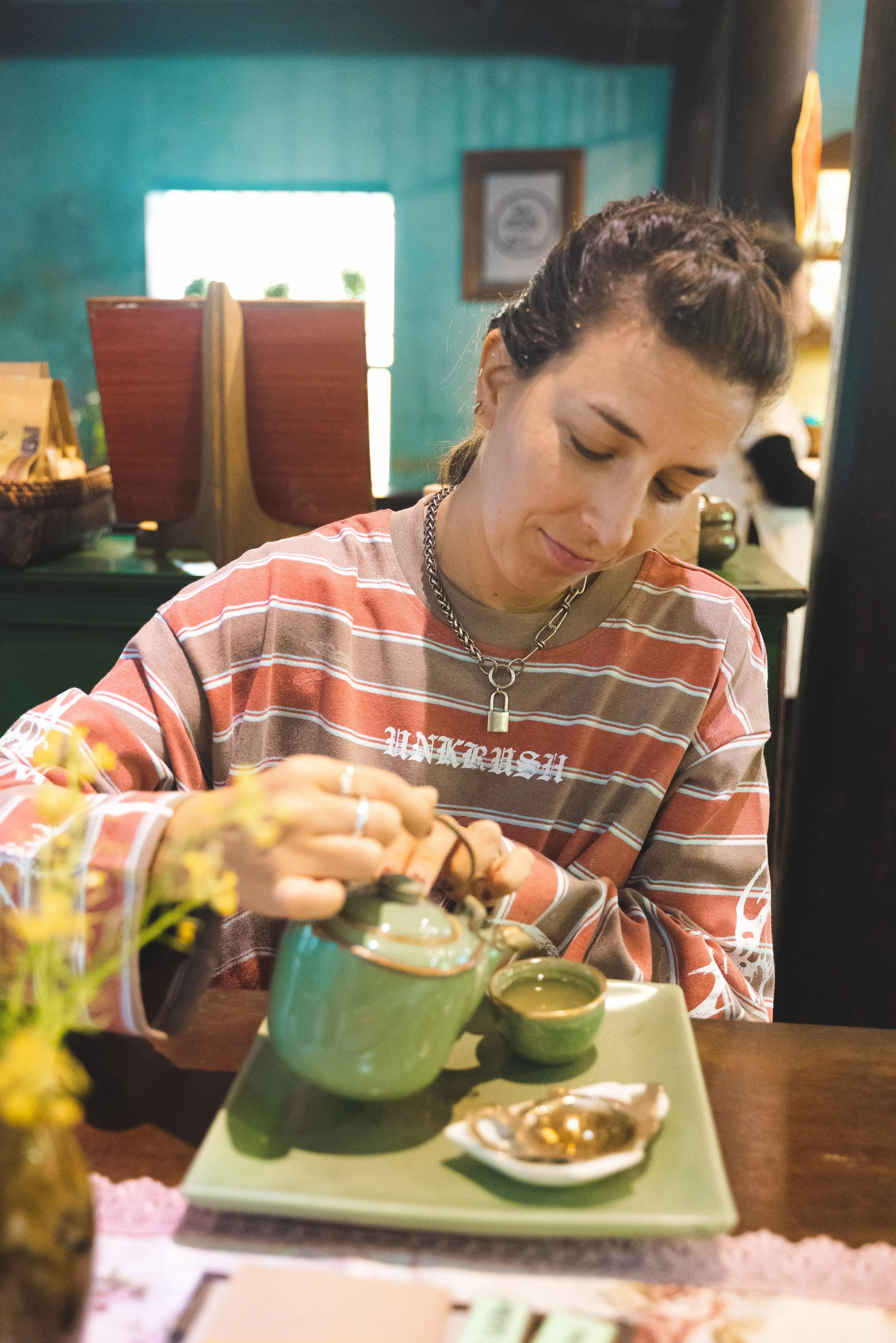 girl pouring tea at reaching out tea house hoi an
