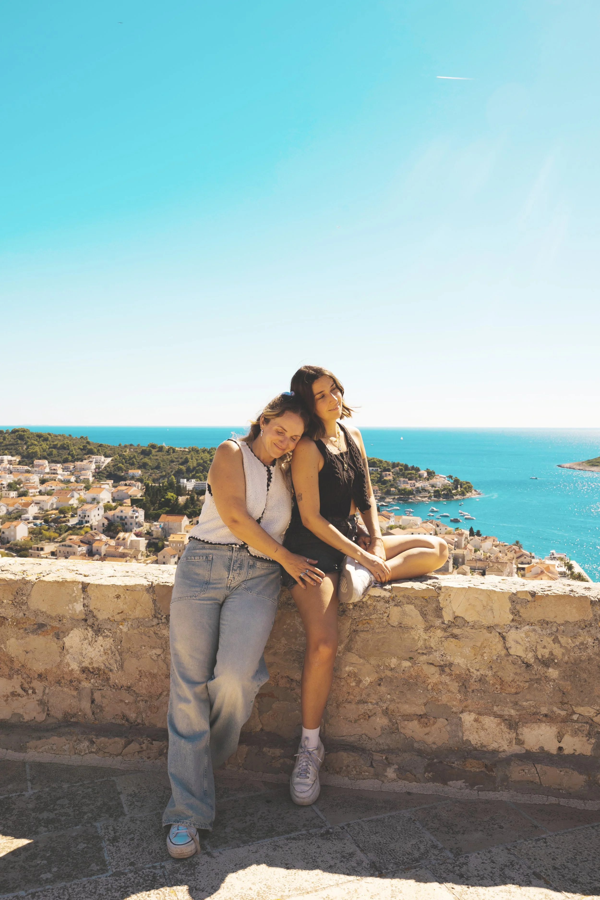 two girls sitting on top of spanish fortress hvar