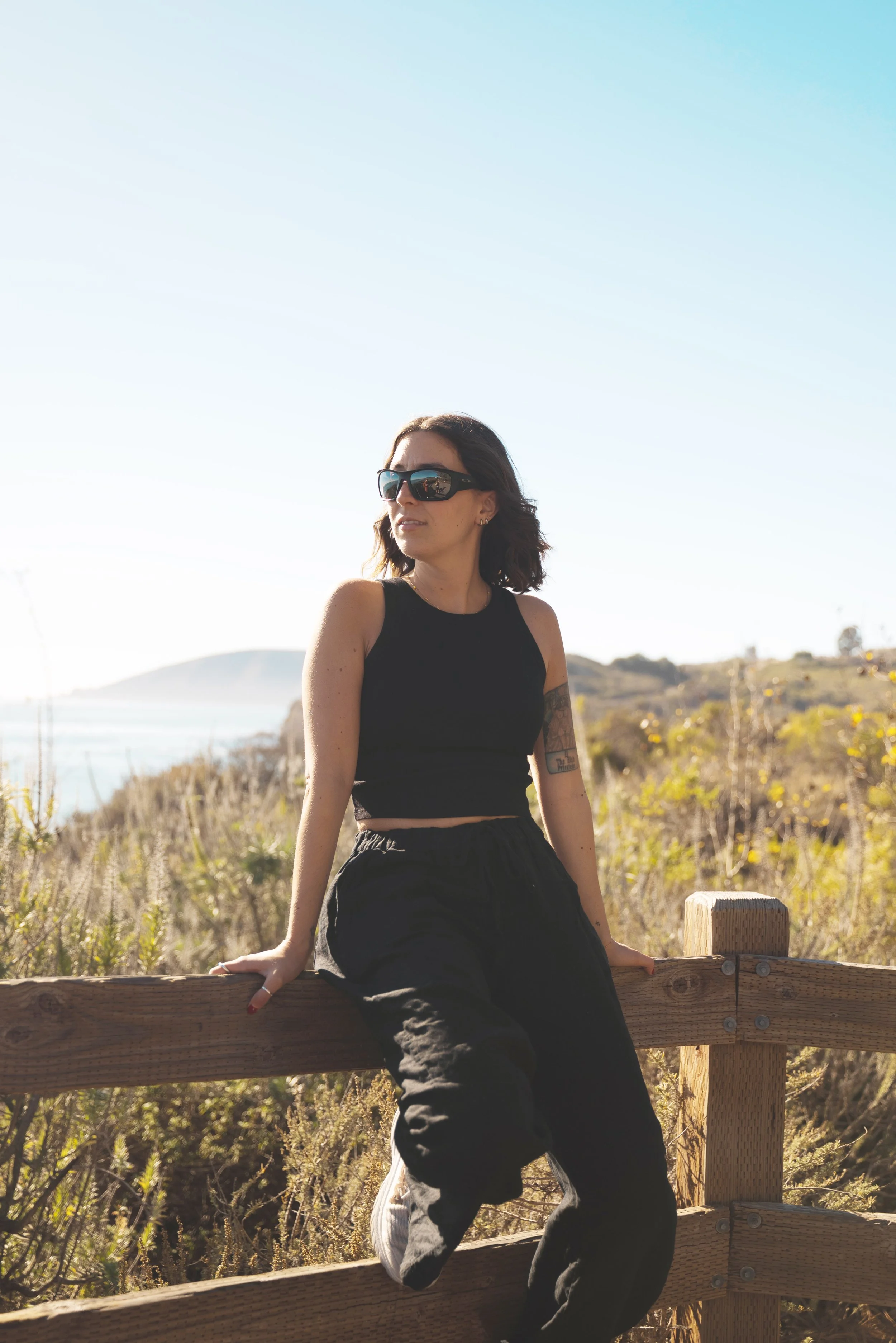 girl sitting on fence at pismo beach SLO CAL