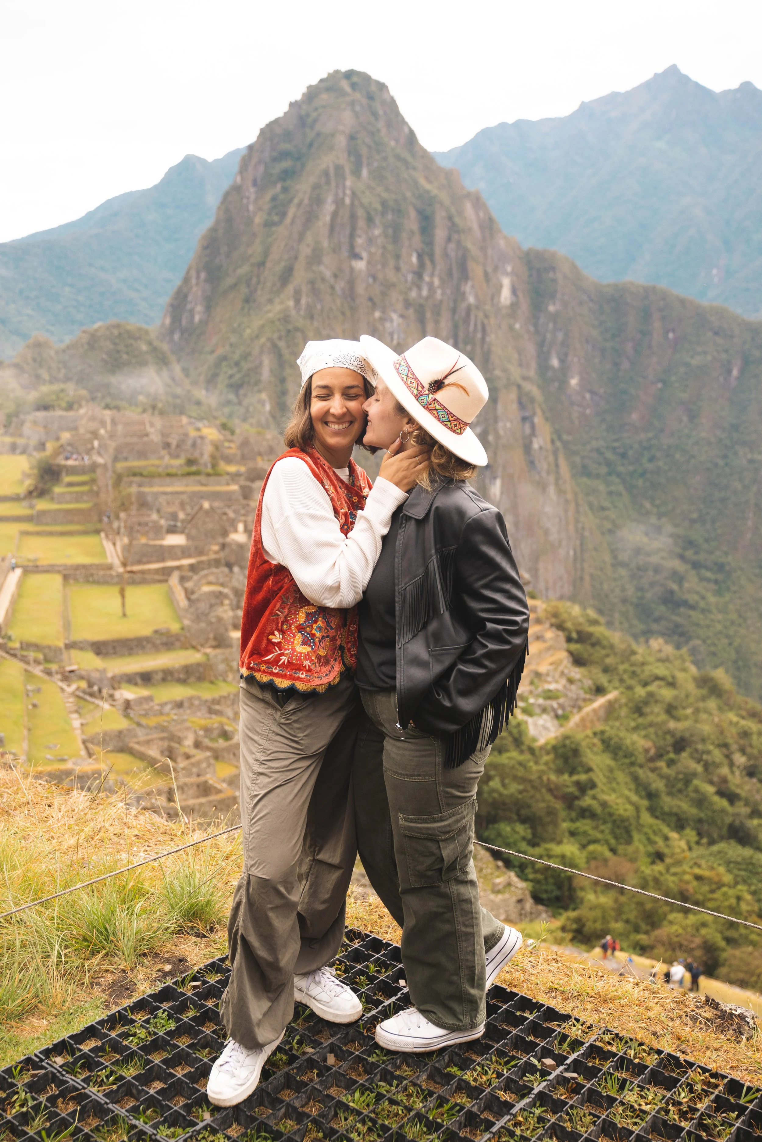 two girls hugging in front of machu picchu peru