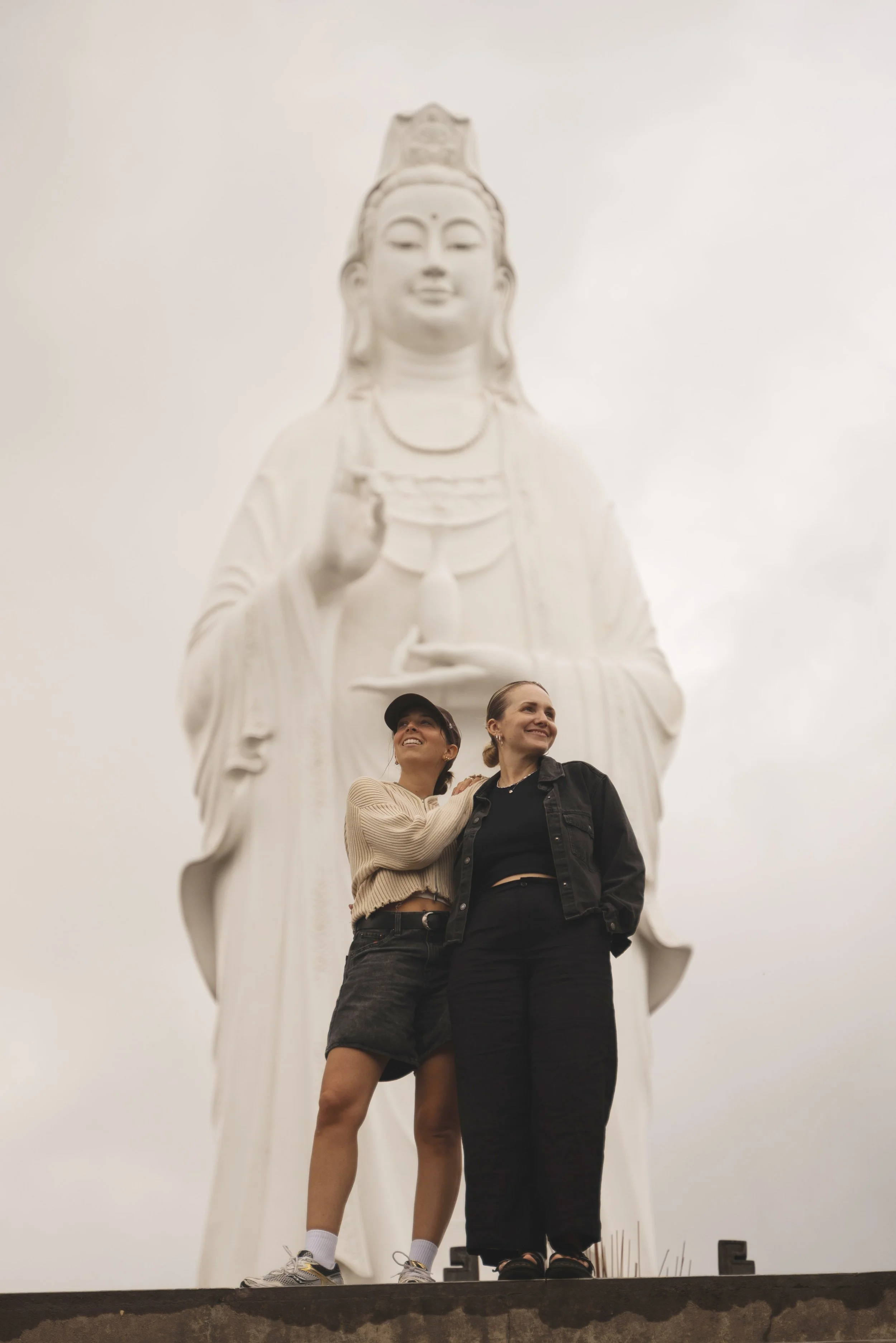 two girls standing in front of lady buddha statue da nang