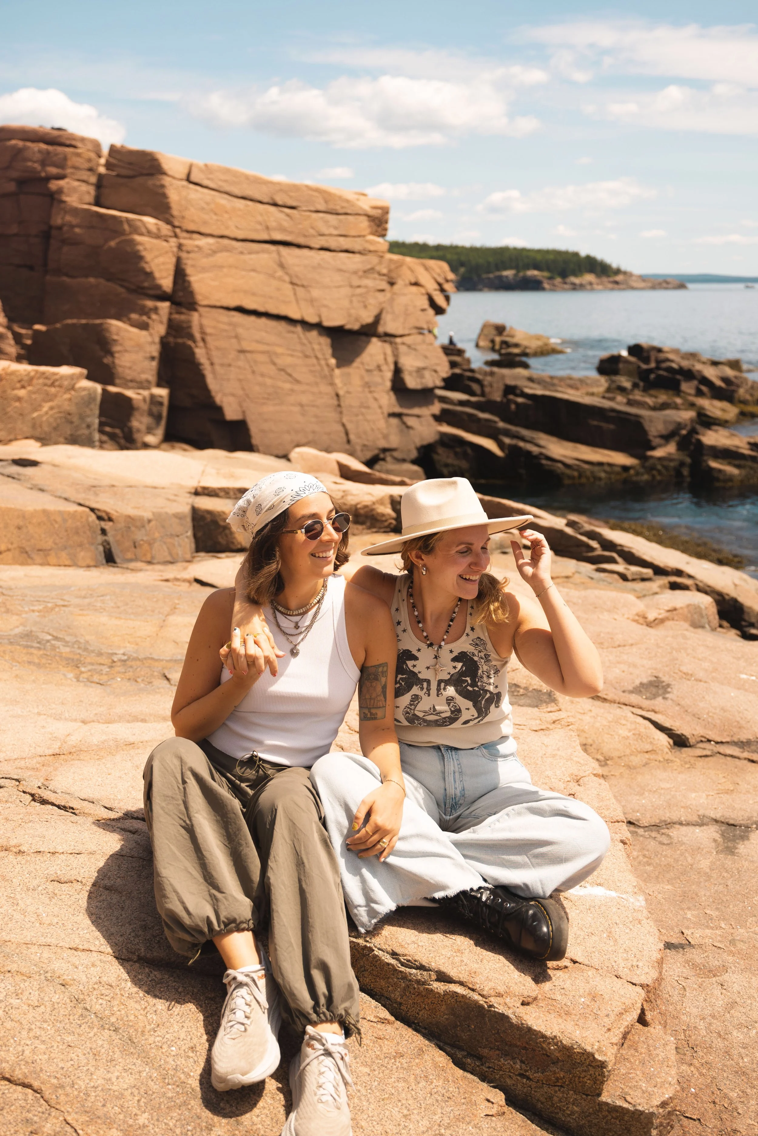 two girls sitting in front of thunder hold acadia national park