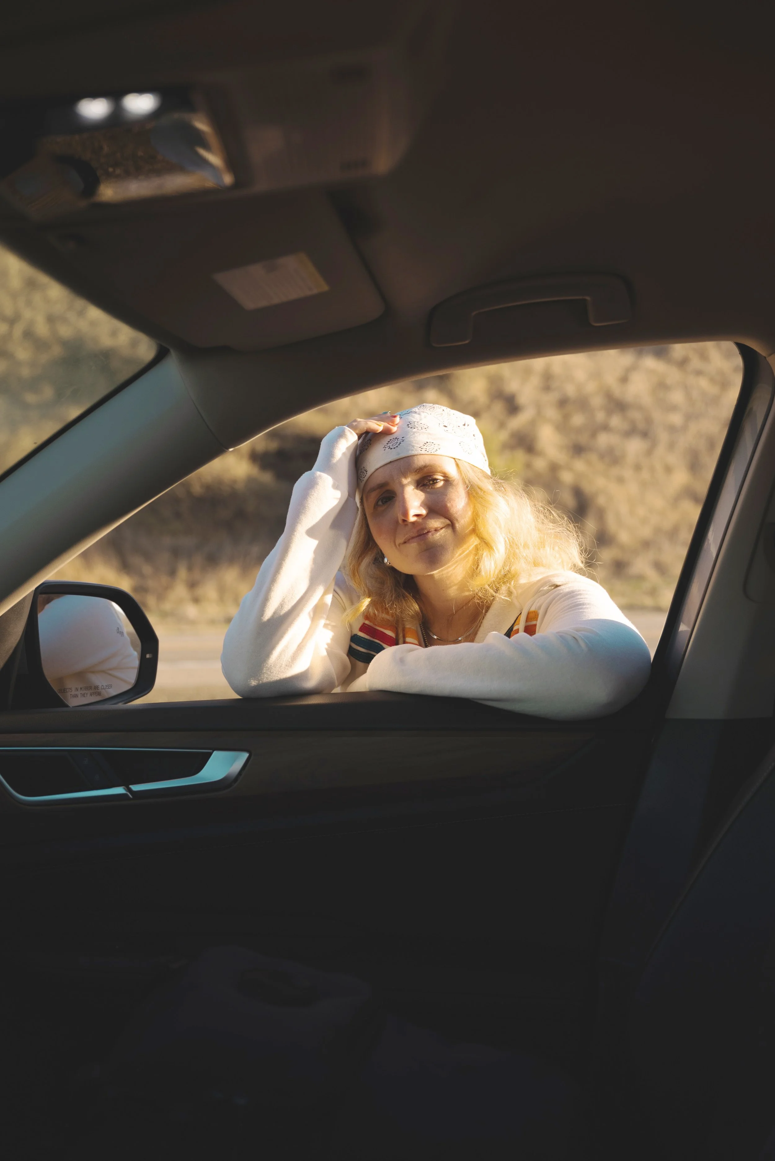 girl looking through car window on california road trip