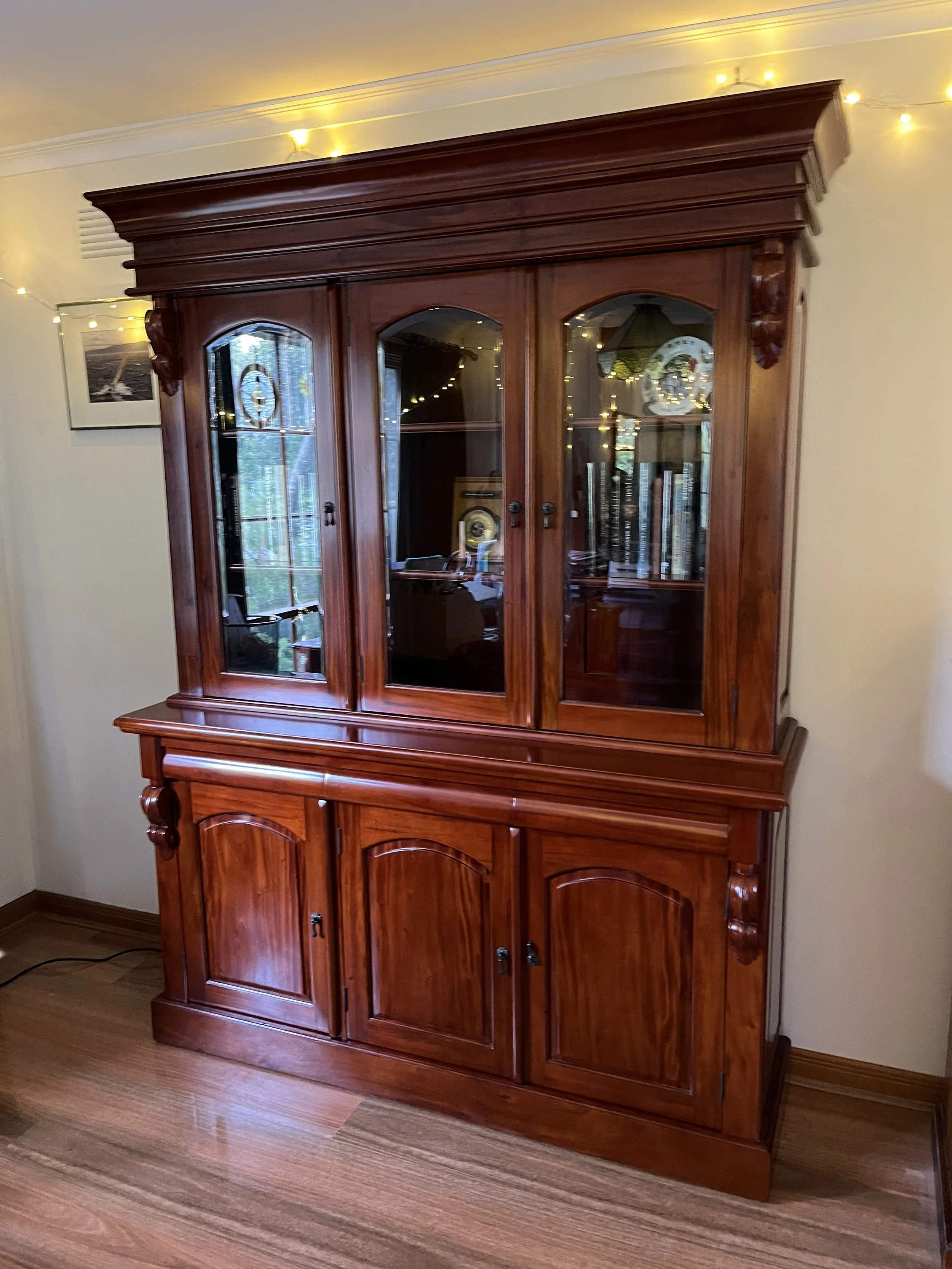 ornate-glass-door-display-cabinet-with-string-lights.jpeg