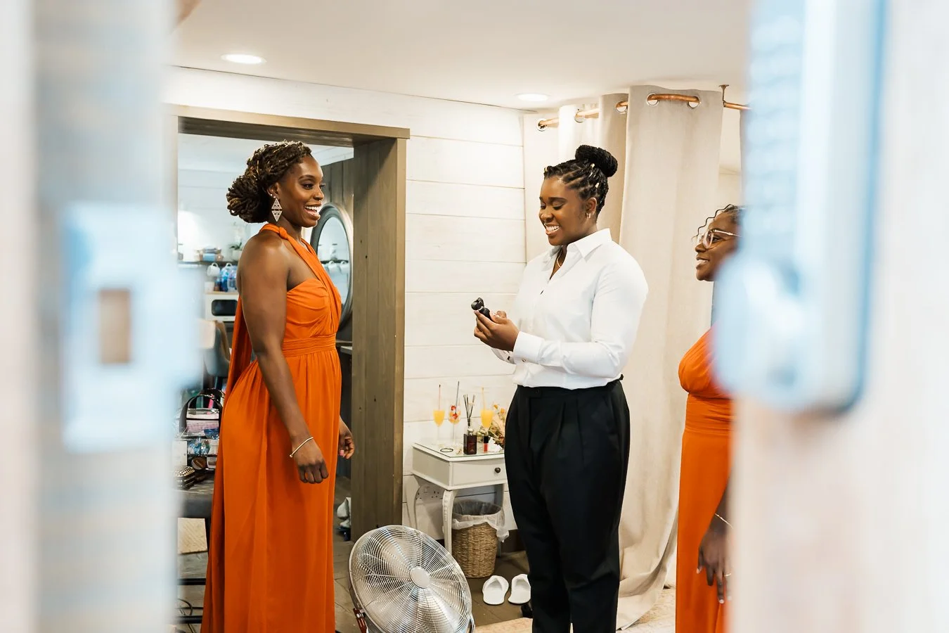 Groom and party smiling through the crack  in a door 