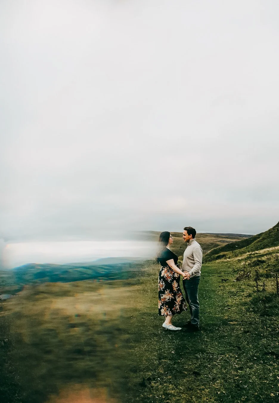 Couple holding hands-on a hillside during engagement photoshoot