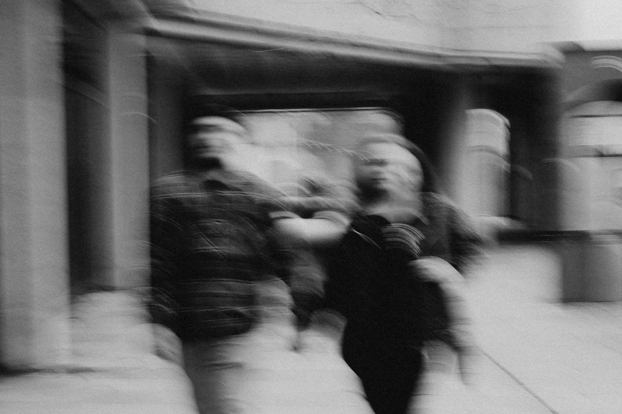 Black and white creative image of a couple walking through Cardiff holding hands 