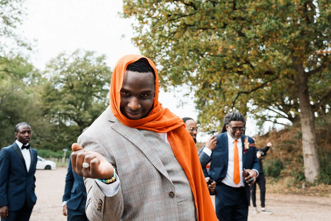Guest wearing a bright orange scarf over his head looking into a camera