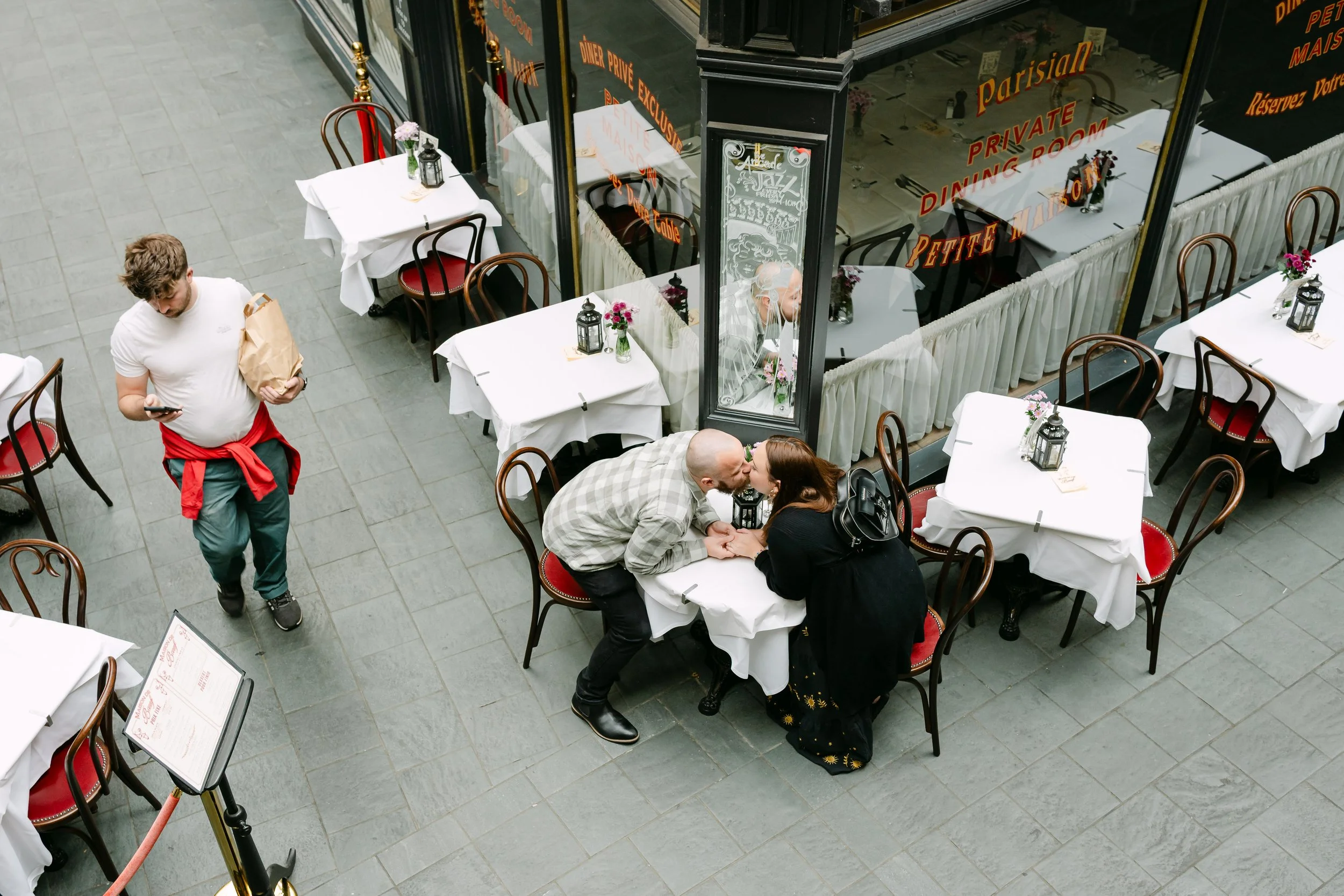 Engagement couple kissing at Parisian style outdoor cafe, aerial view romantic urban photography, Cardiff