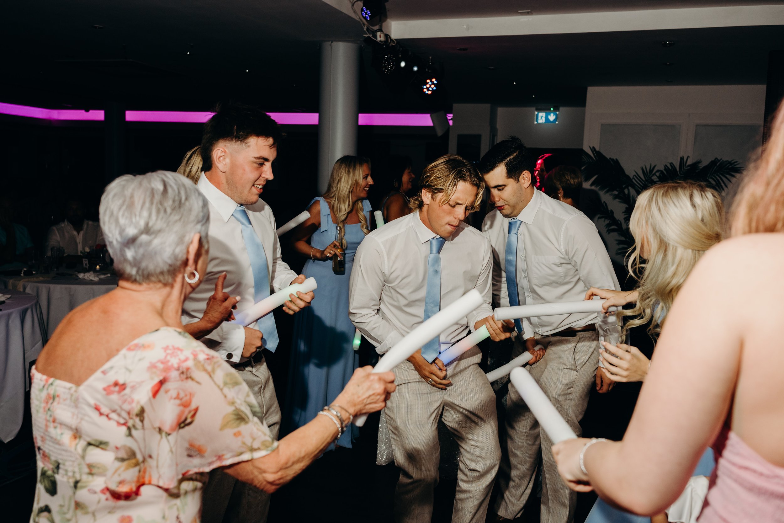 Dancing at a wedding party paying with foam tubes 