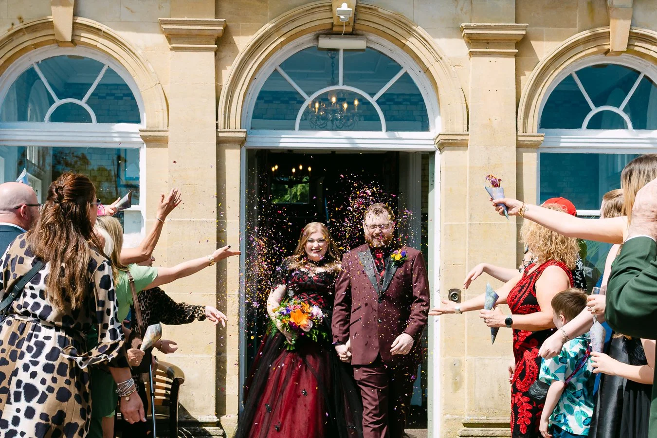 Bride & groom holding hands during confetti throw at court Colman hotel Bridgend