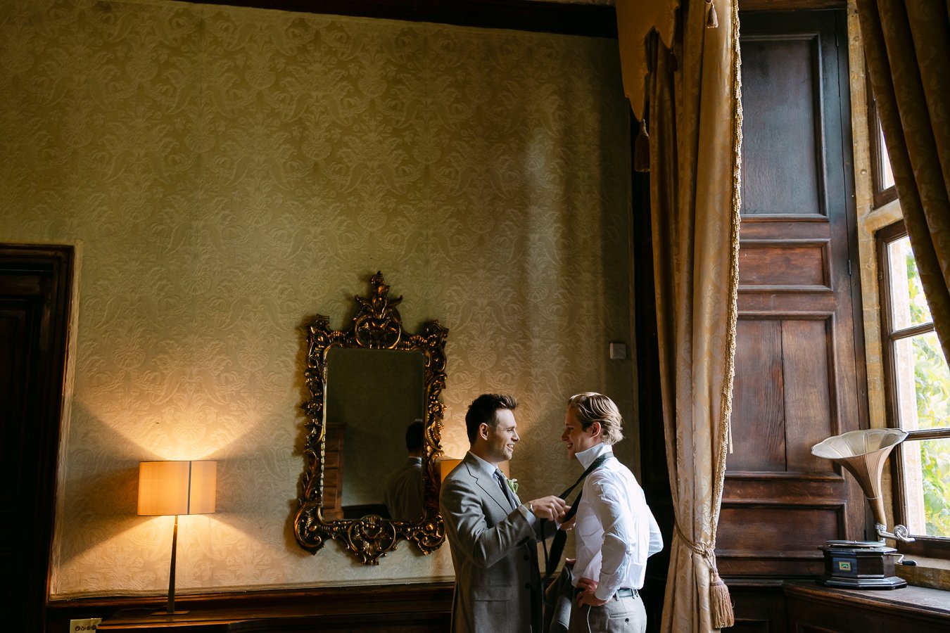 Groom doing up his bastmans tie 