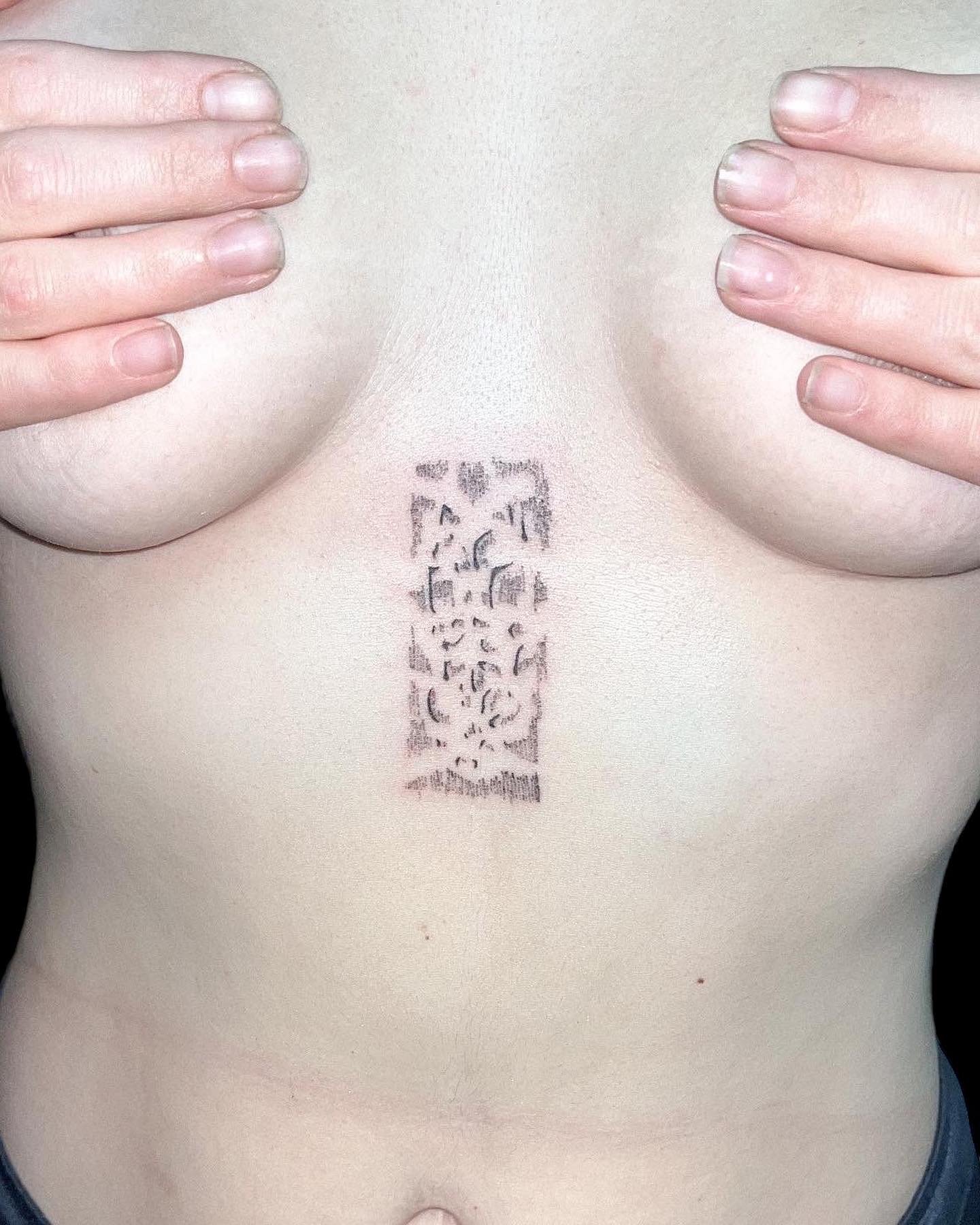 Abstract tattoo between breast handpoked by ay seed.JPG
