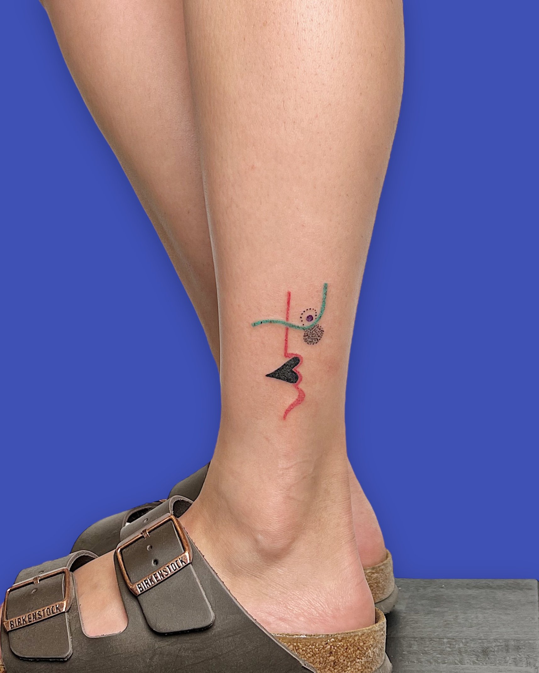Small and simple asbtraction of a face tattooed on the ankle by madame Unikat.JPG