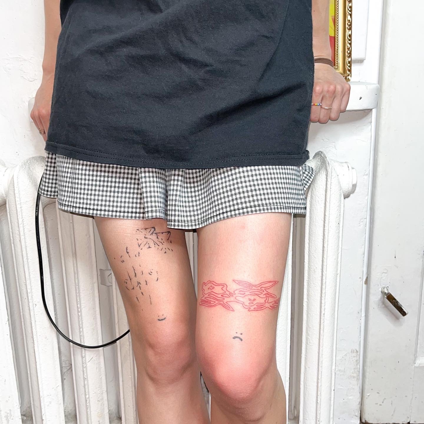 Composition of a red outlined shape and delicate black ornaments tattooed on legs by ay_seed.jpg