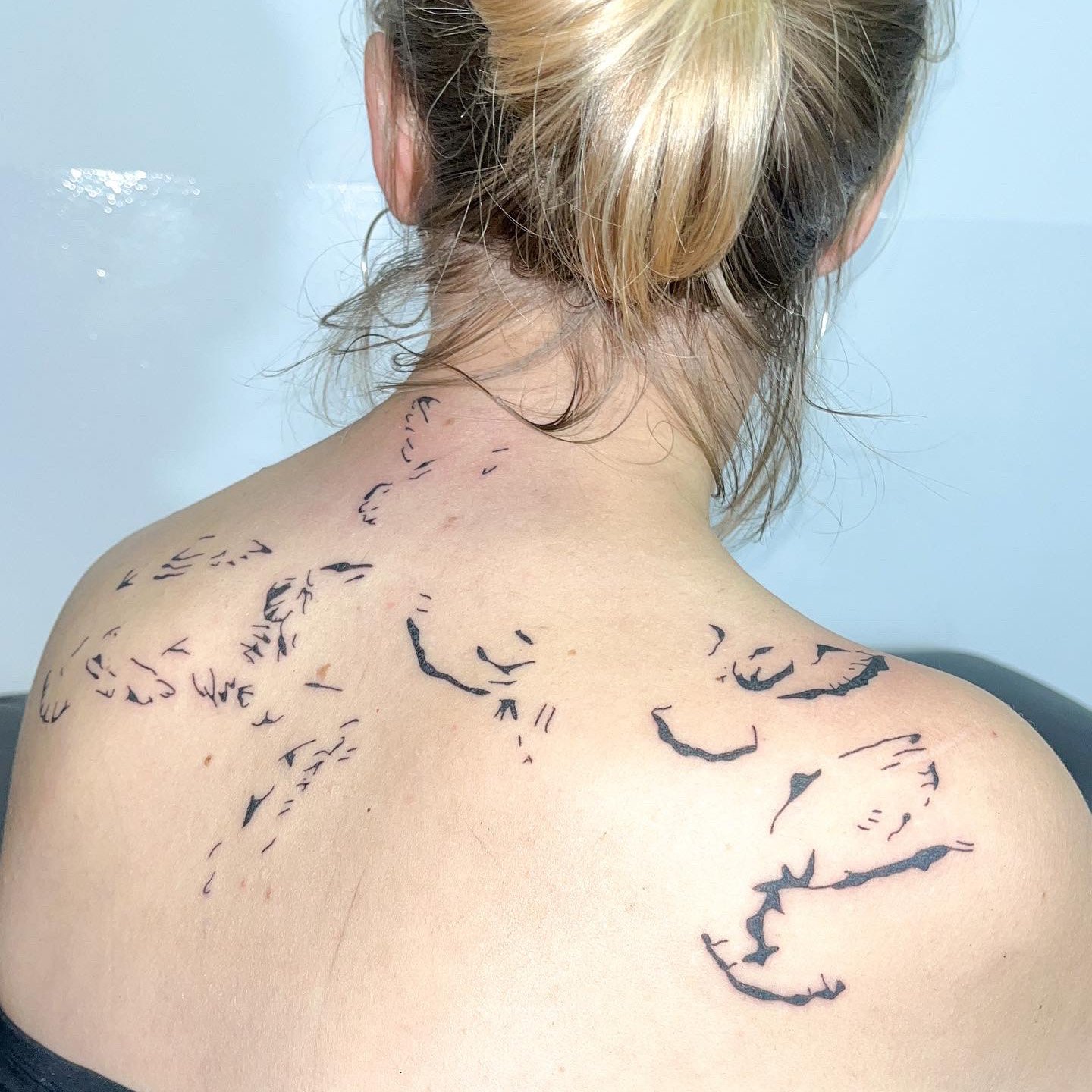 Upper back tattoo made with abstract shapes in black by ay_seed.jpg