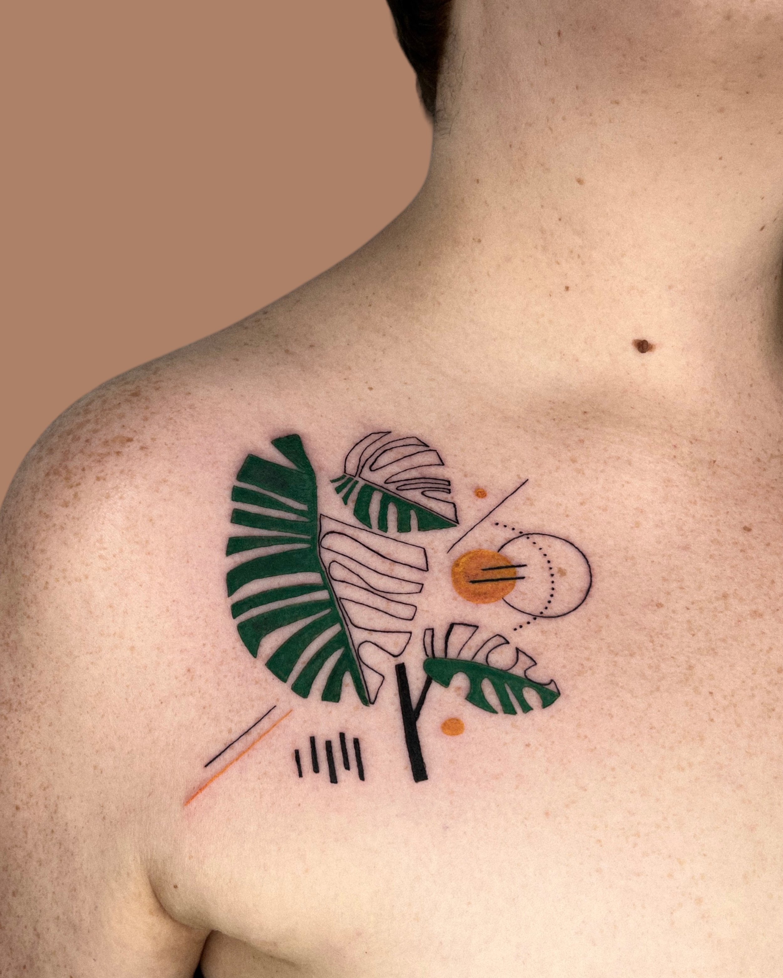 Composition with Monstera leaves on collar bone tattooed by kirii lines.JPG