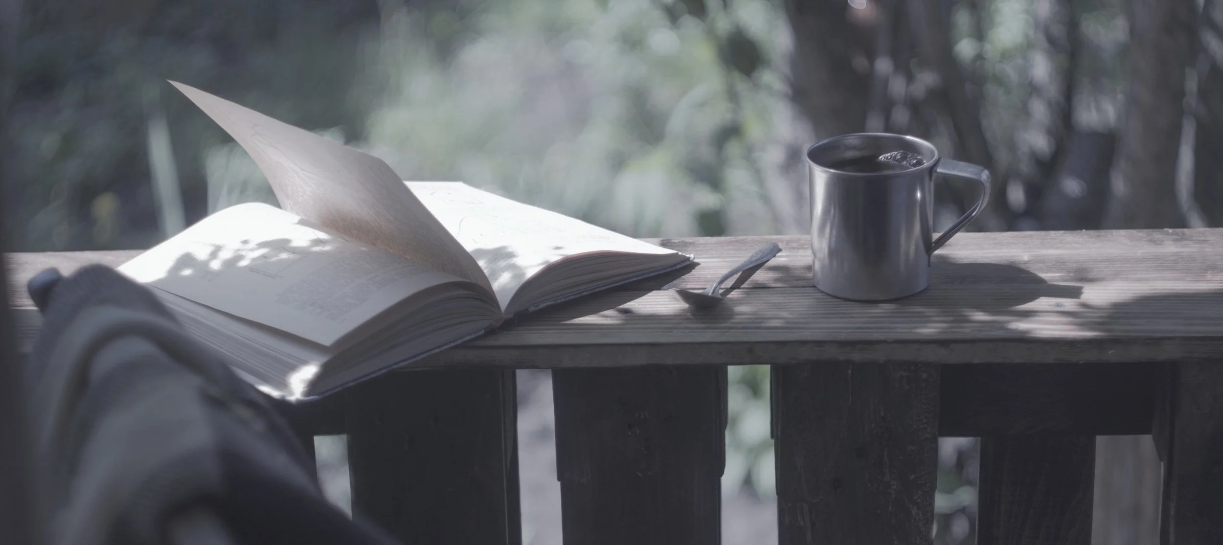 Copy of Metal mug, book and chair on a wooden terrace