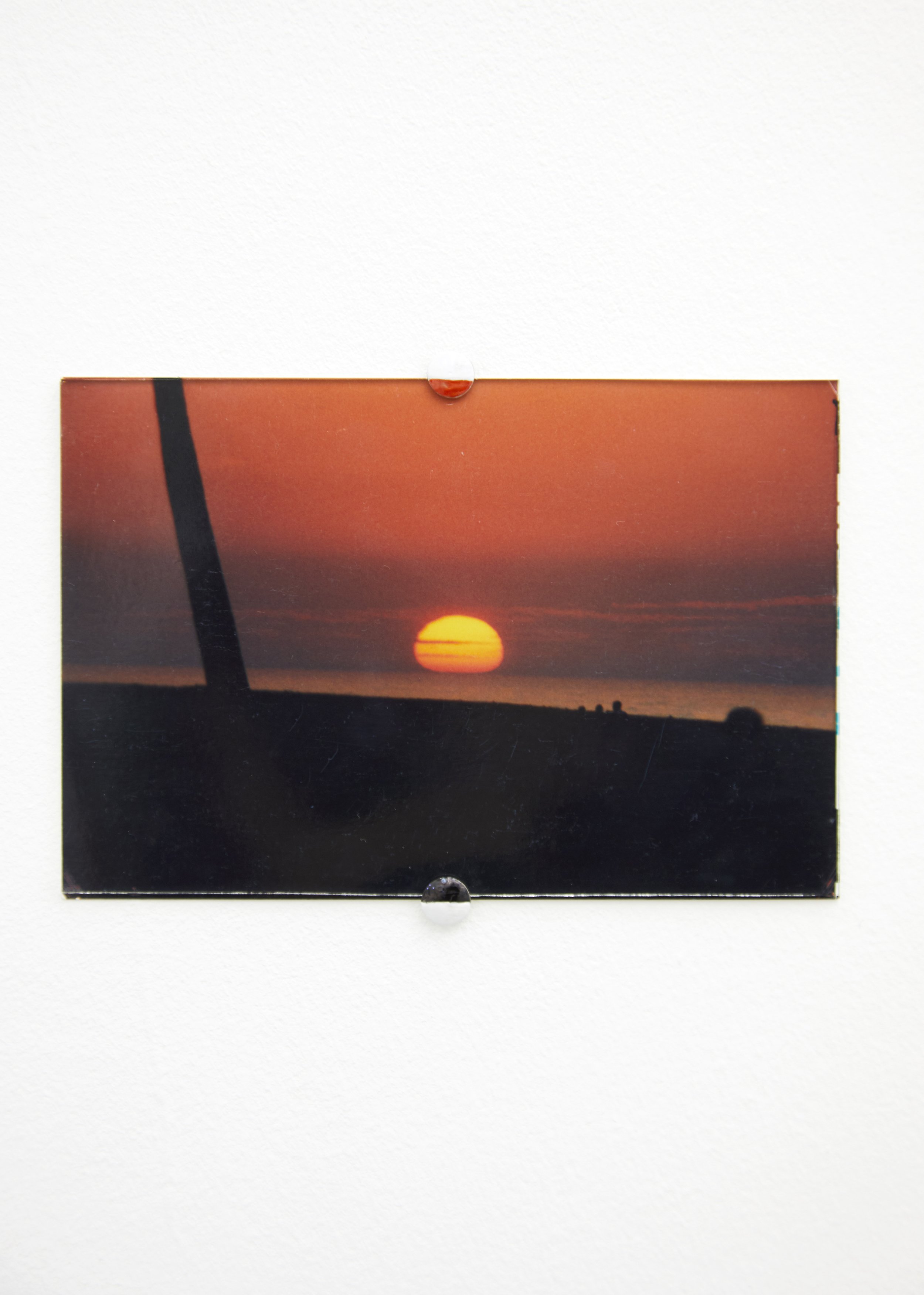  THE SETTING SUN, 2022, found photograph, glass, pins 