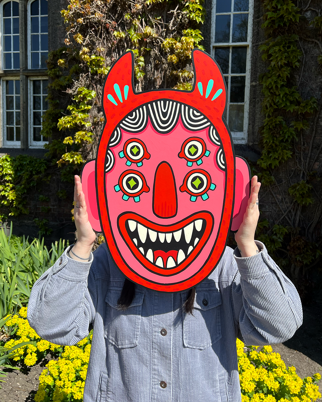 person holding a devil mask