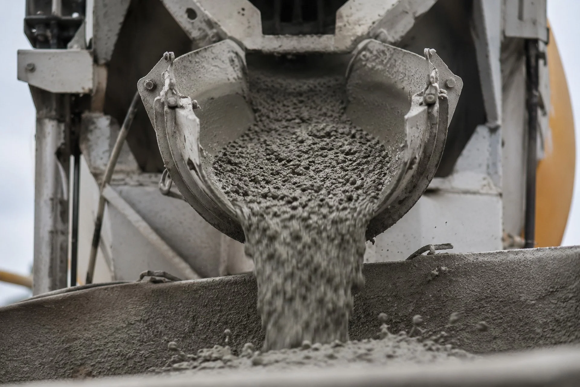 Concrete mixer pouring wet concrete into a mold.