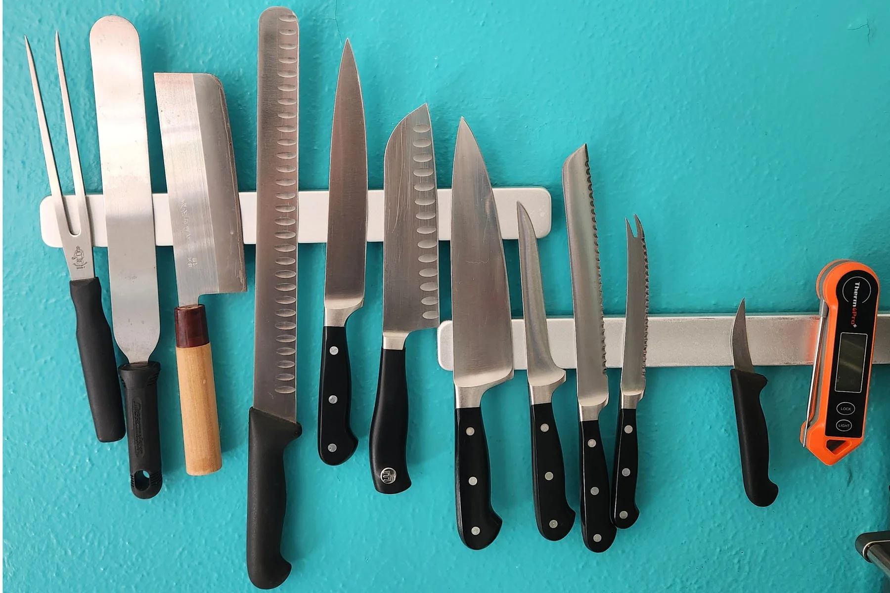 Knives hanging on magentic strips to free up counter space in  small kitchen and make cooking easier.