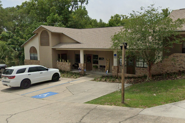 A beige commercial building with a front porch, and a parking area, 366 E Graves Ave, Ste E Orange City, FL 32763