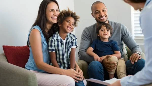 Happy family in family therapy talking about child therapy and play therapy for their two children
