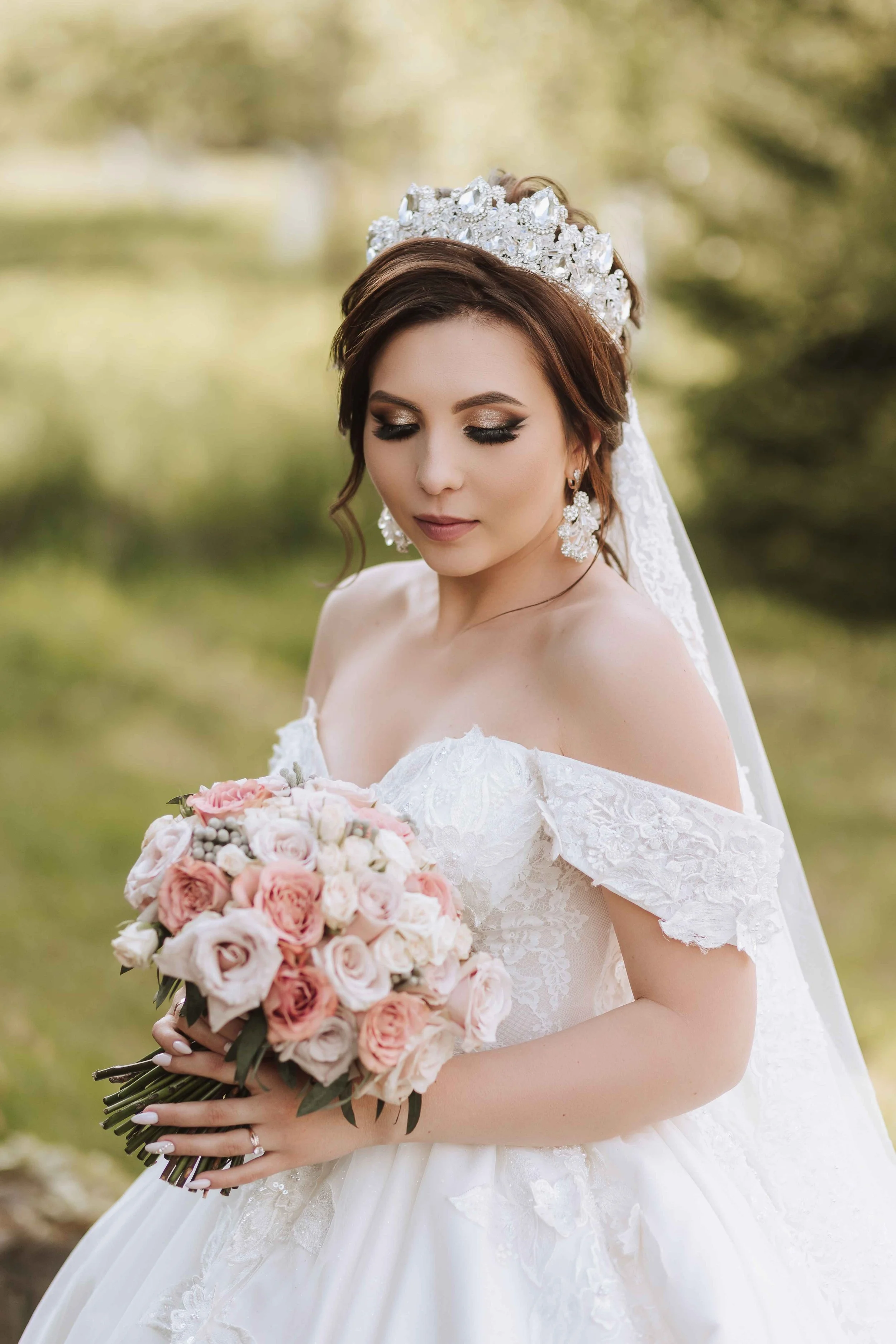 A bride with a bouquet and a tiara outside and walking down the aisle