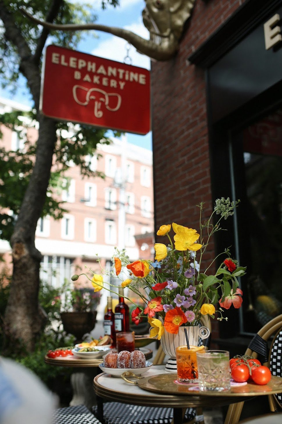 Exterior of Elephantine café in Portsmouth, New Hampshire during summer aperitivo, with guests gathered in a cobblestone alley in the evening.