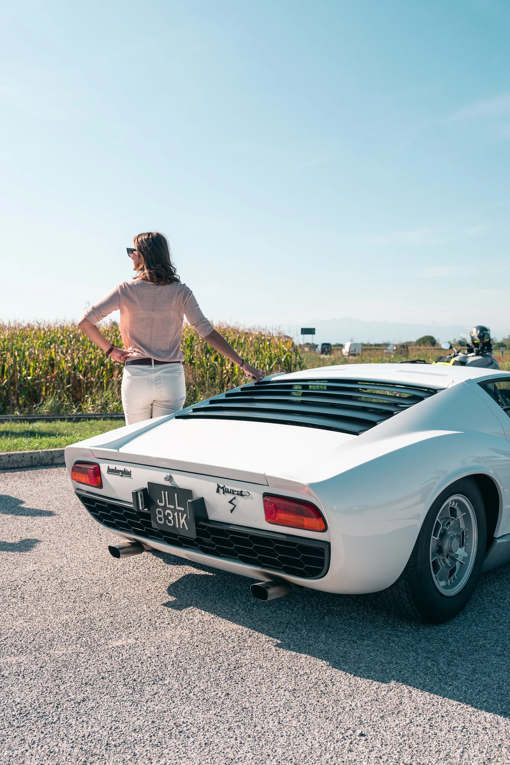 Guest poses with the splendid white Miura, best in her category.